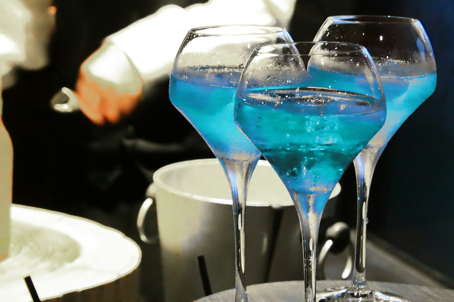 Tre bicchieri di cocktail blu su un vassoio da bar