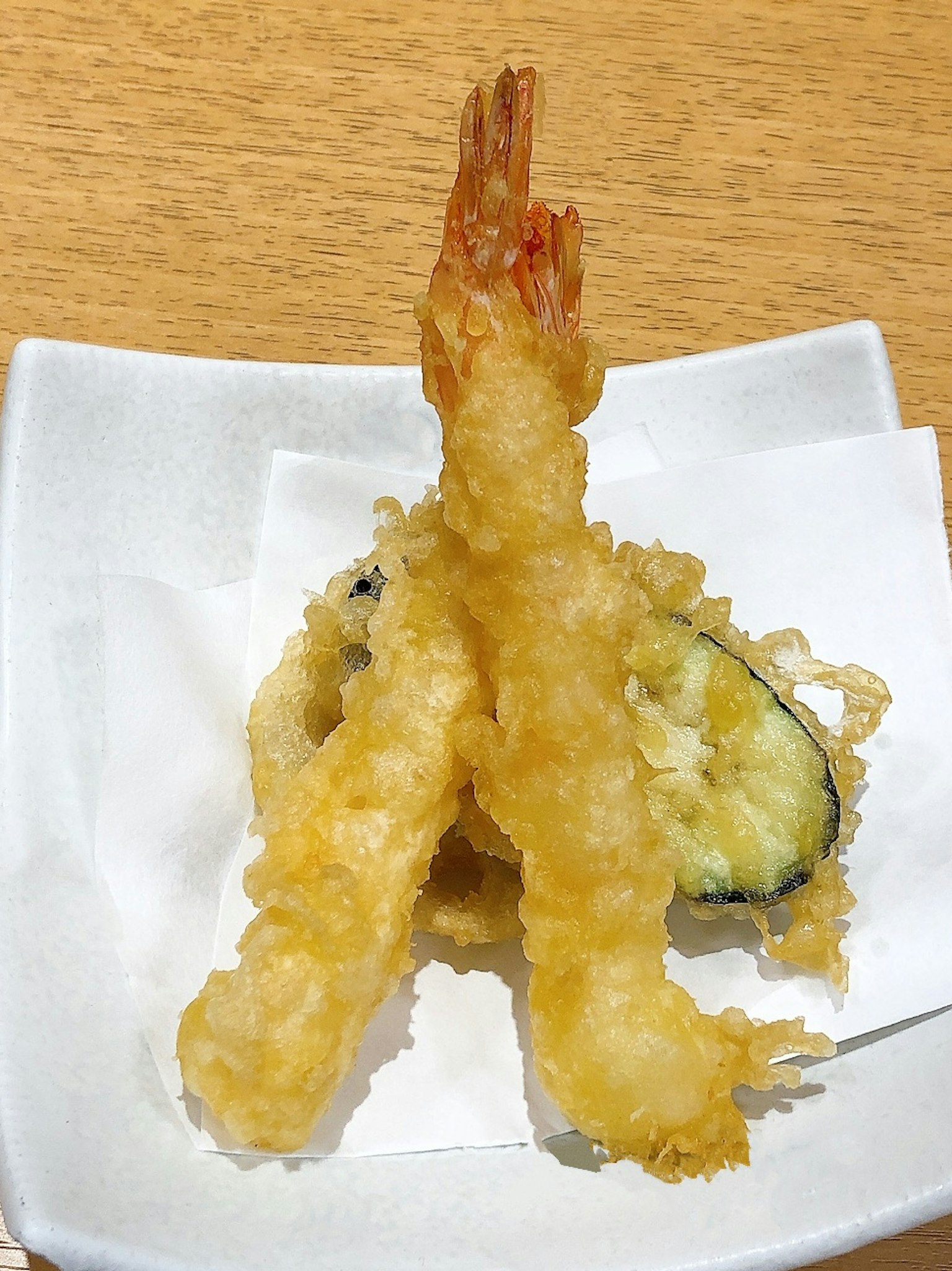 เทมปุระกุ้งสองชิ้นกับเทมปุระผักบนจานสีขาว