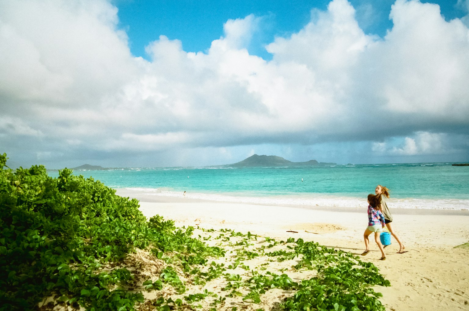 Kinder spielen am Strand mit blauem Meer und Himmel