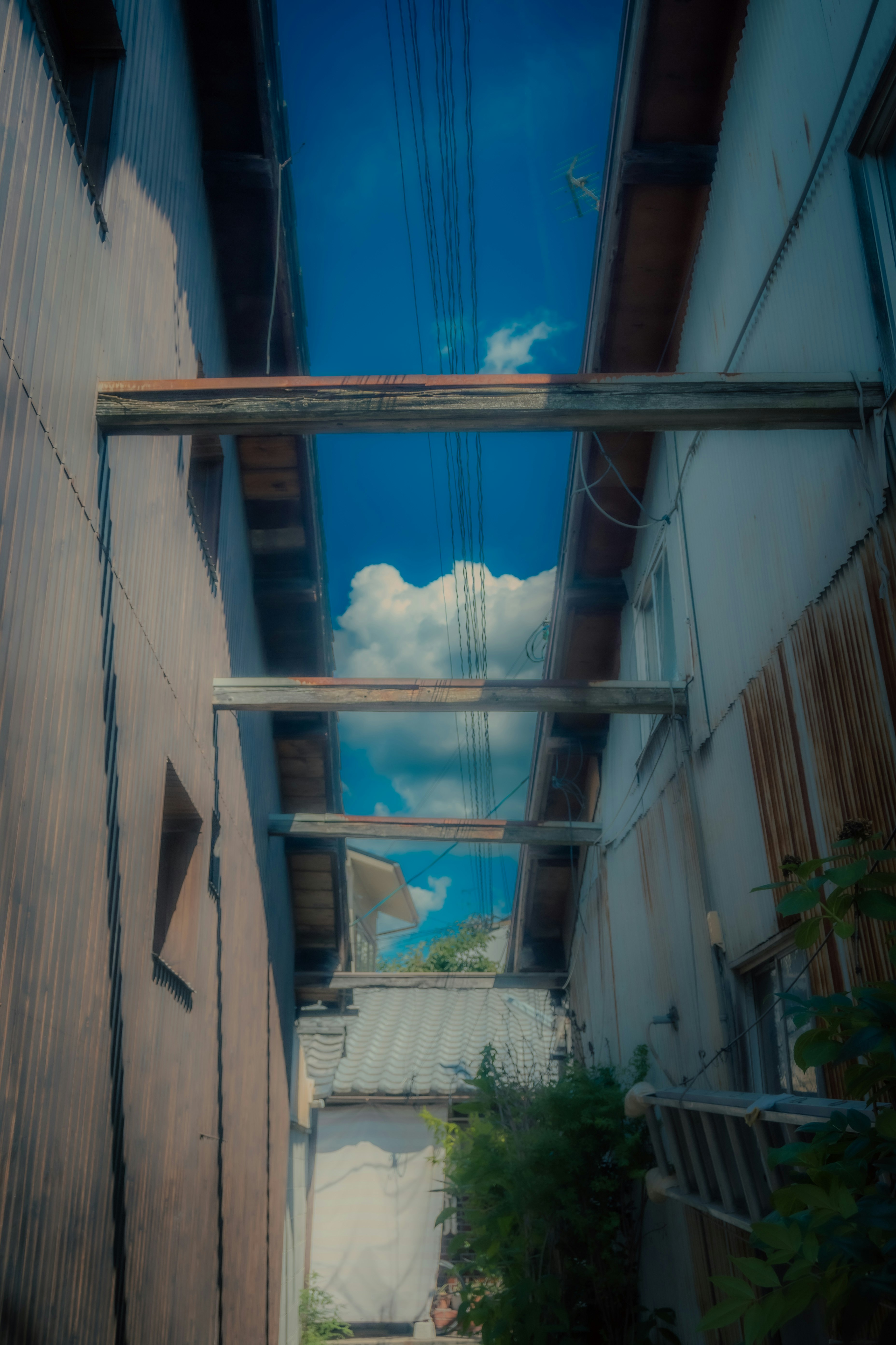 Narrow alley with wooden beams and blue sky clouds