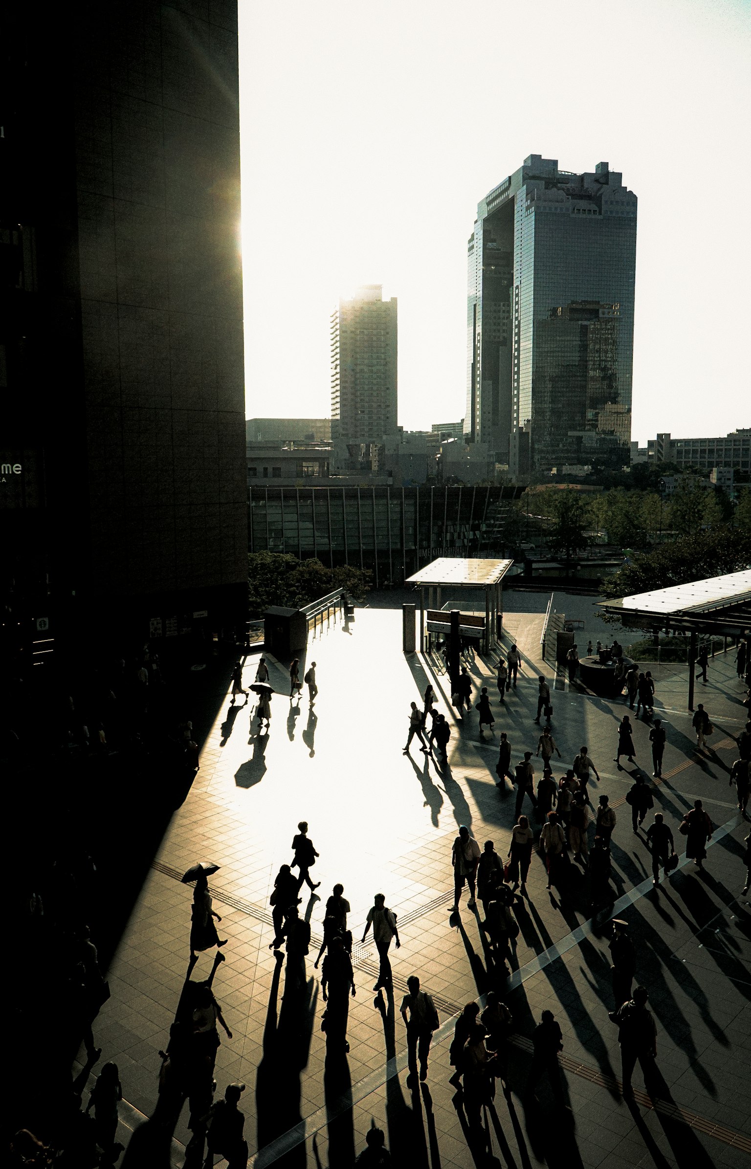 Paisaje urbano con personas en silueta contra el atardecer