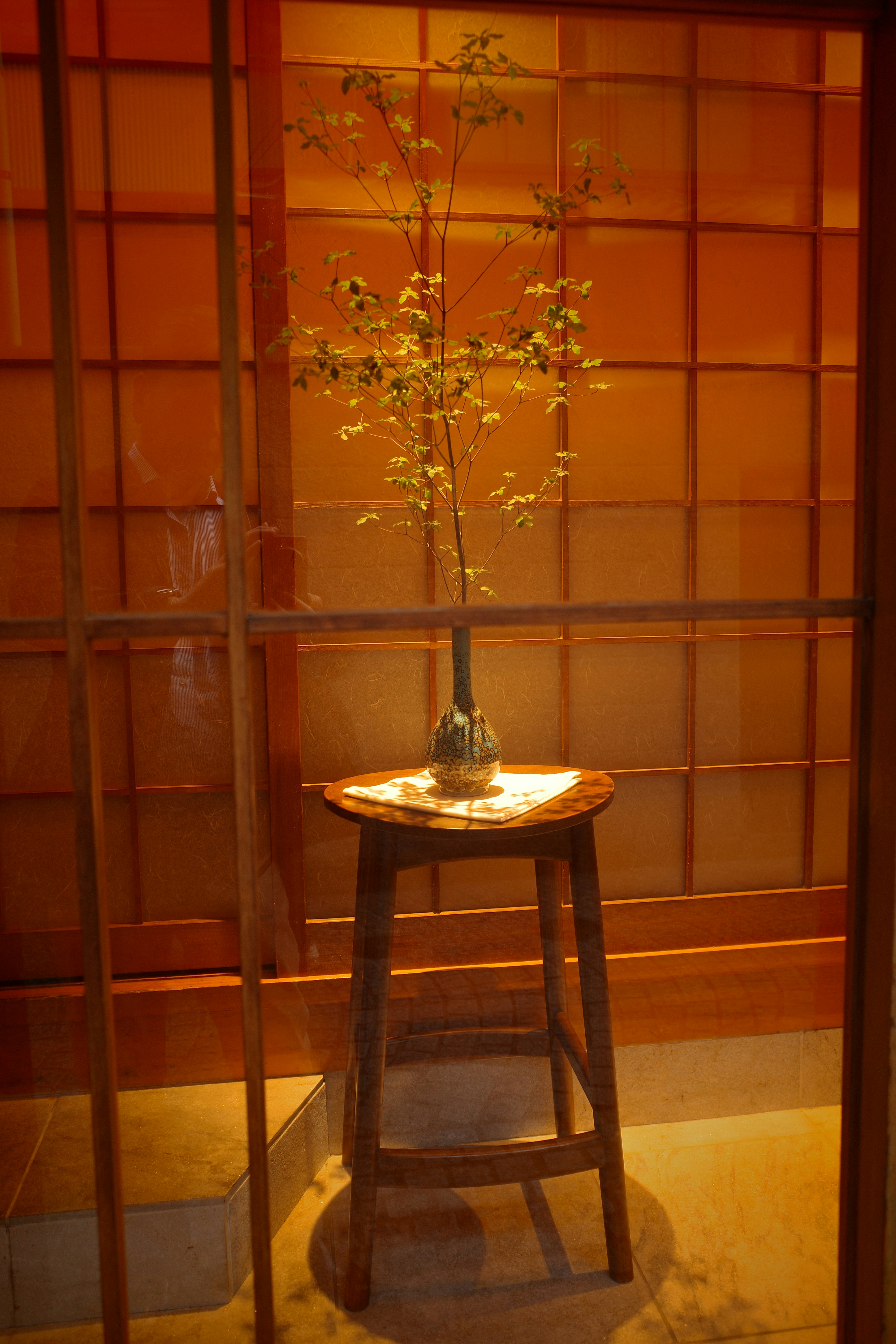 障子のある和室の灯りと花瓶の小さな生け花