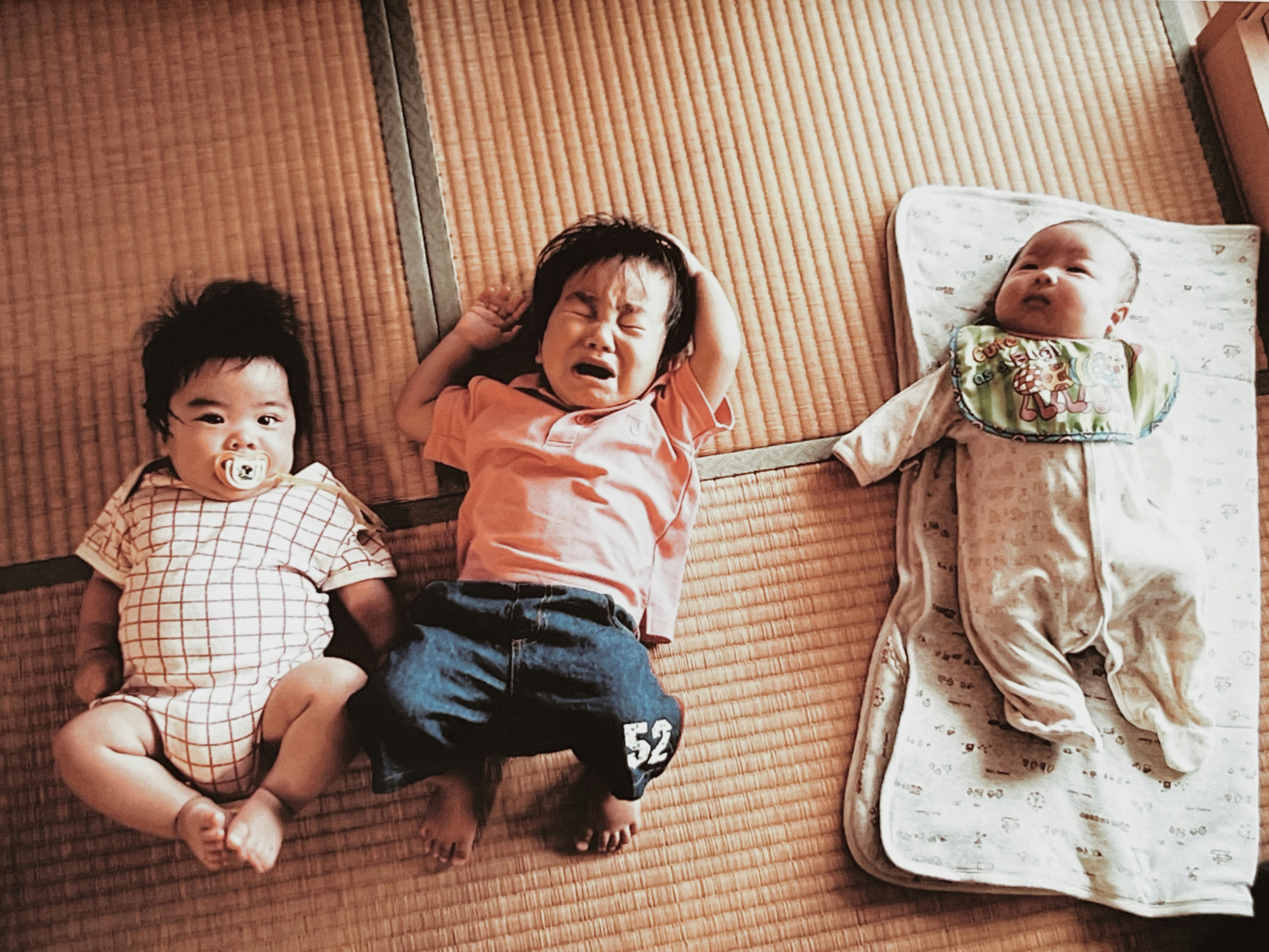 三人の子供が畳の上で寝ている様子