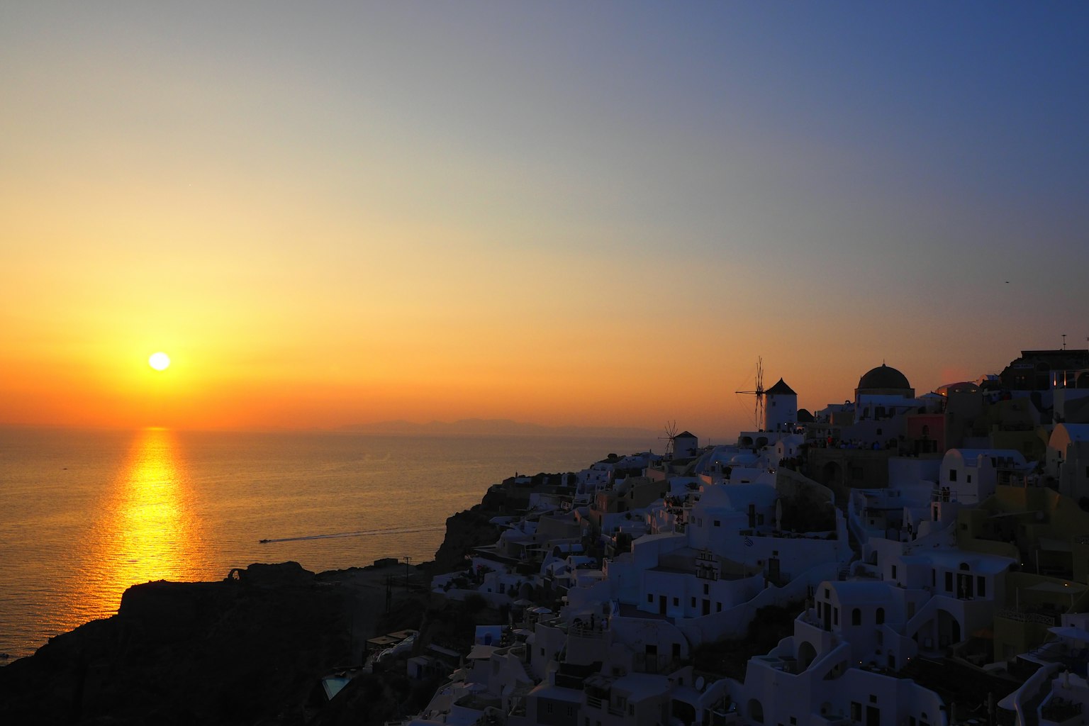 Stupendo tramonto sul mare a Santorini edifici bianchi sulla collina