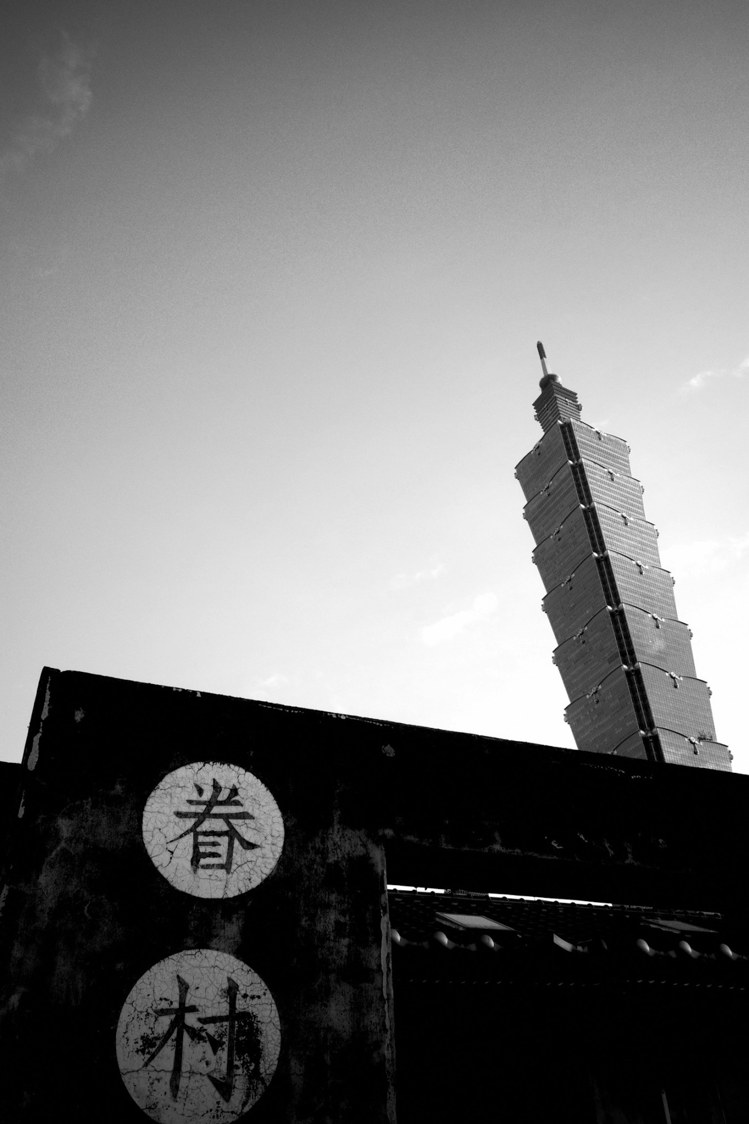 台北101的黑白照片 显示建筑的上部和汉字标志