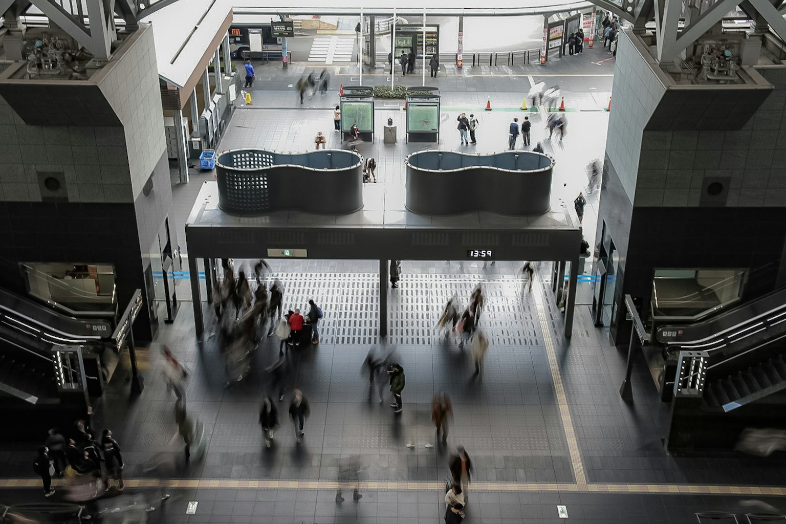 Pemandangan pintu masuk stasiun dengan gerakan orang yang kabur