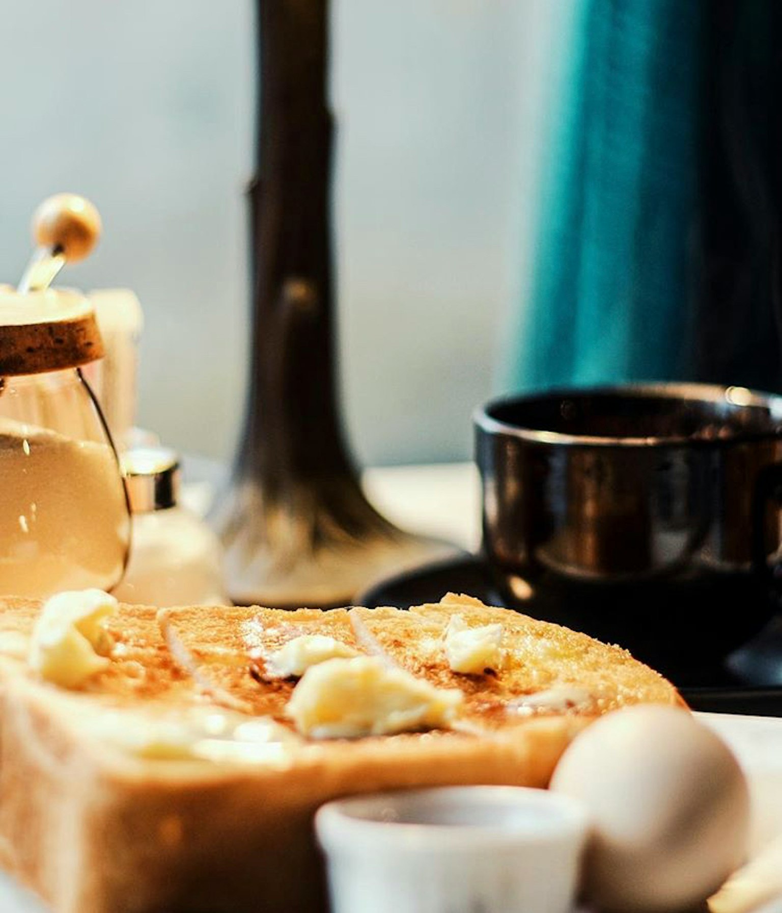 Scena di colazione con toast al burro, una tazza di caffè e un uovo