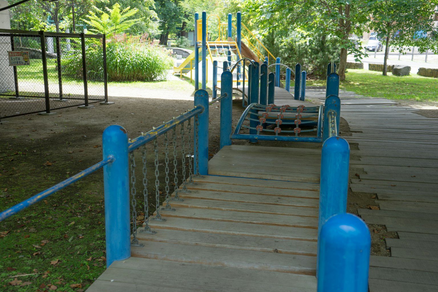 Spielplatzbrücke mit blauen Geländern und Holzboden