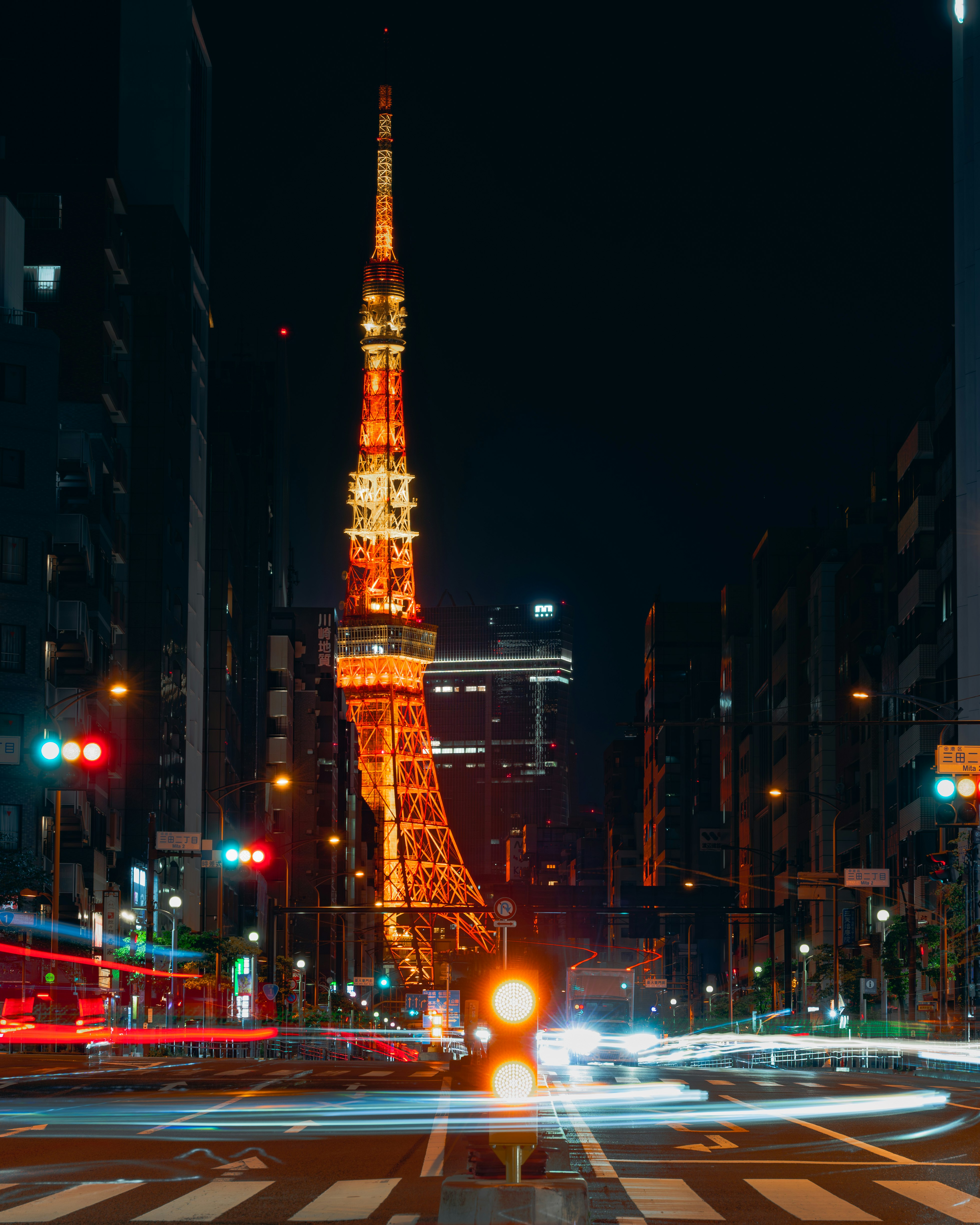 夜の東京タワーを望む交差点の街並み