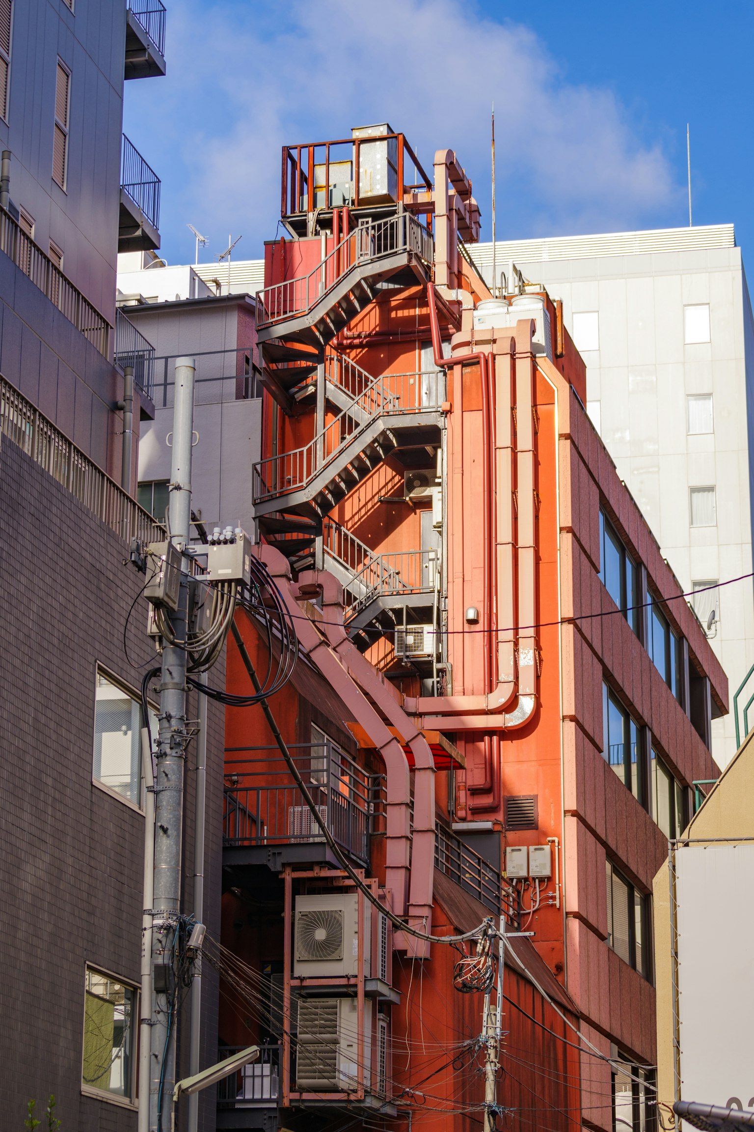 Esterno di un edificio con scale e tubi rossi