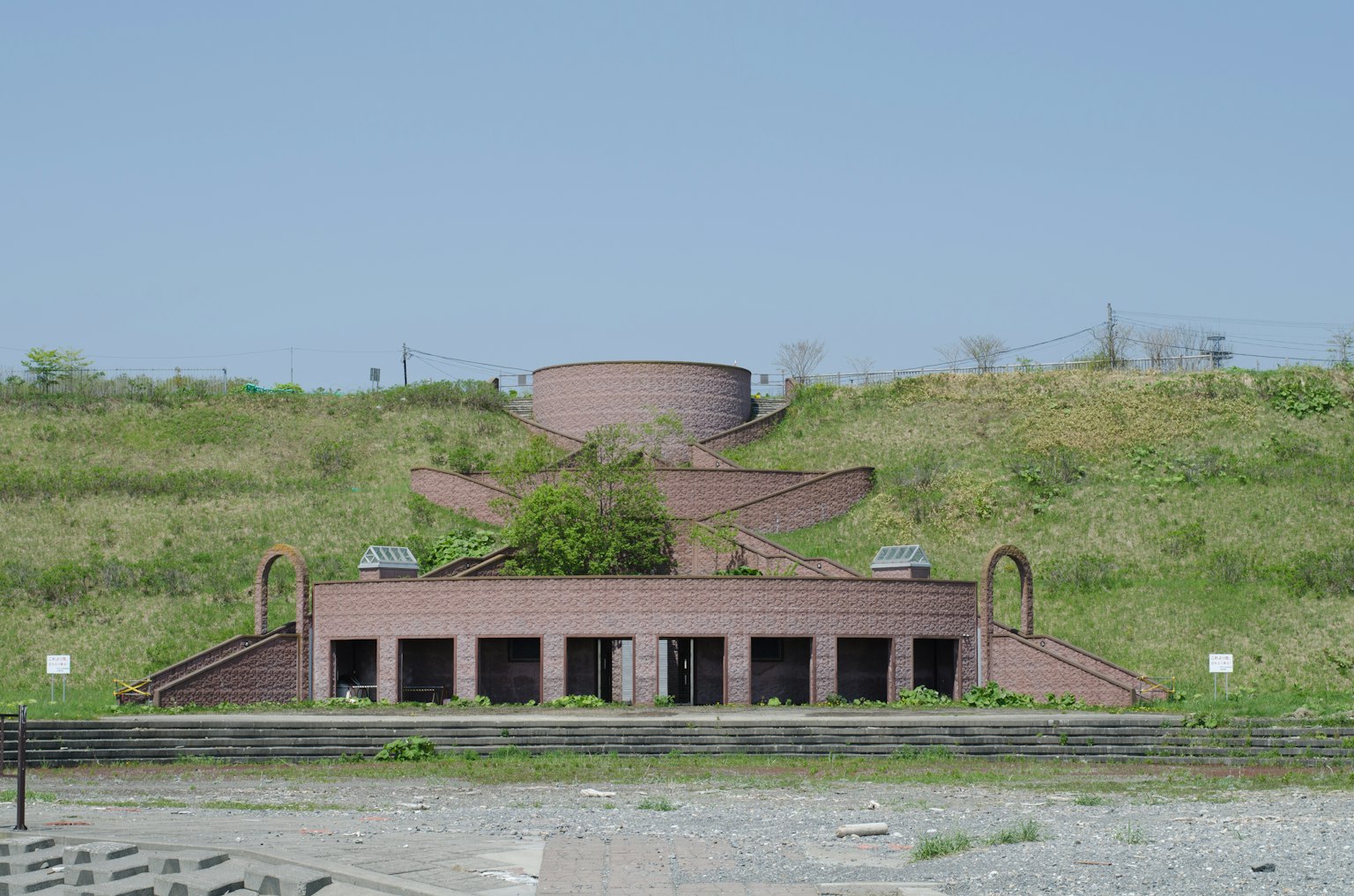 Bâtiment unique avec des escaliers sur une colline verdoyante