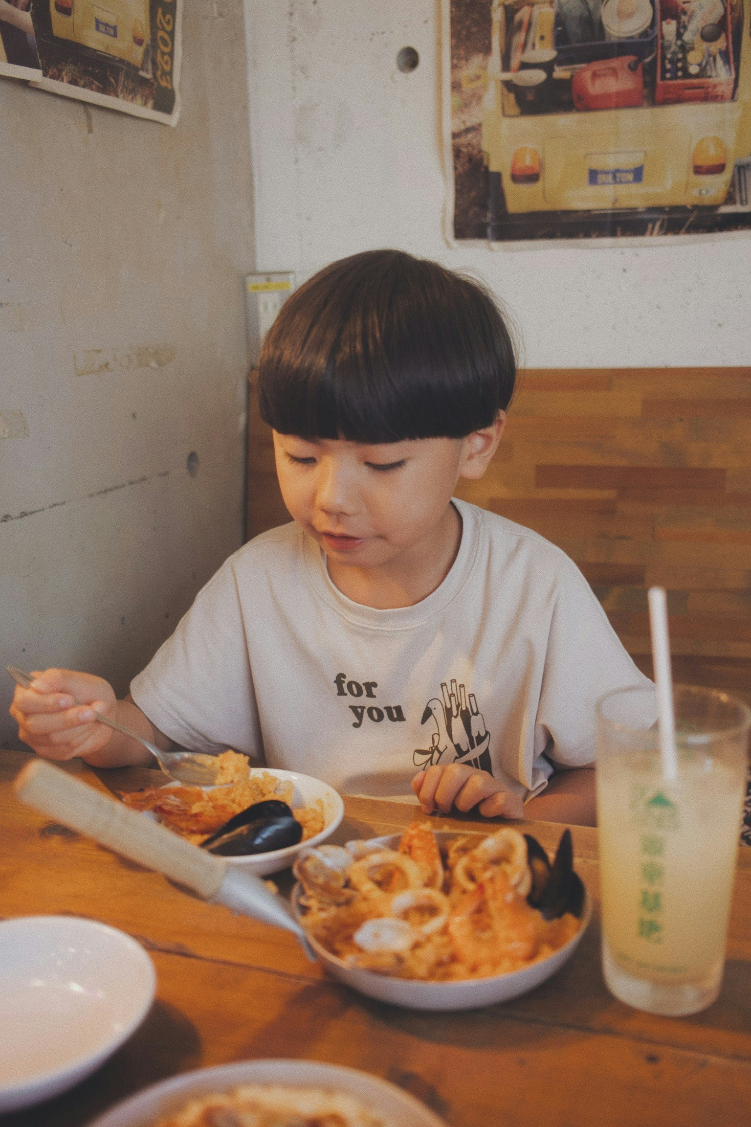 一個孩子在桌子上享用各種菜餚和飲料