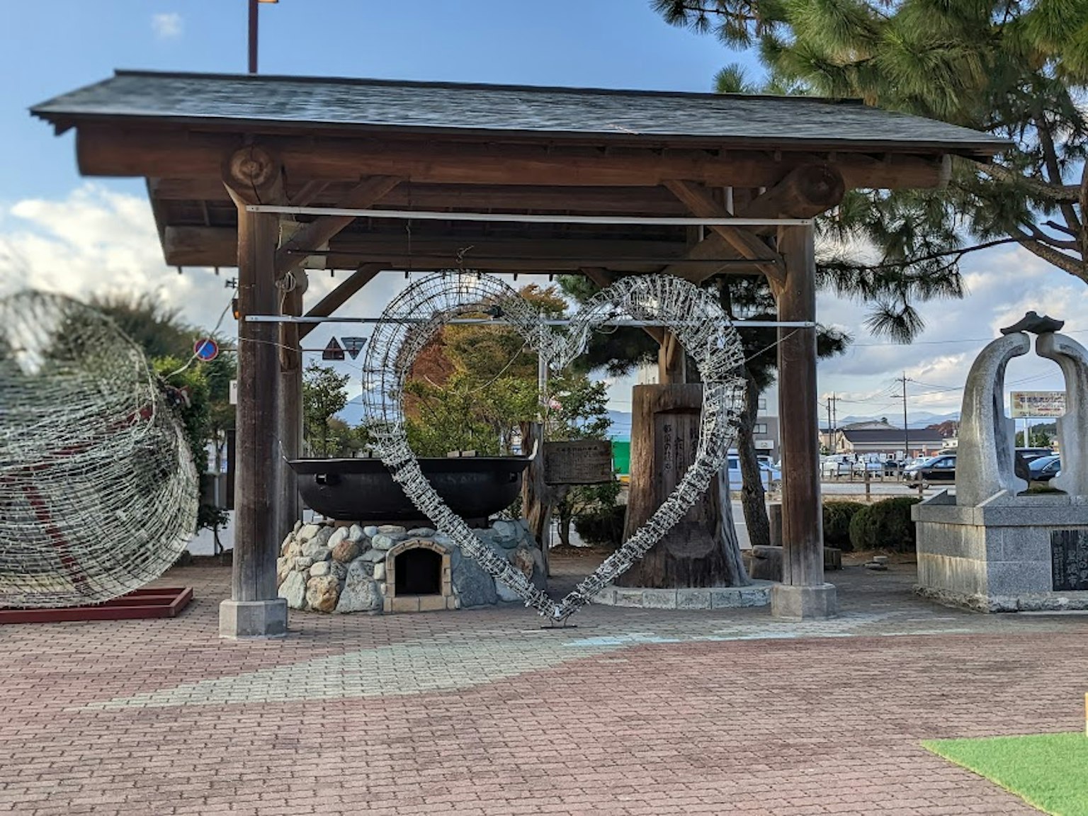 Scena di parco con una struttura in legno e un'opera d'arte a forma di cuore e sculture in pietra