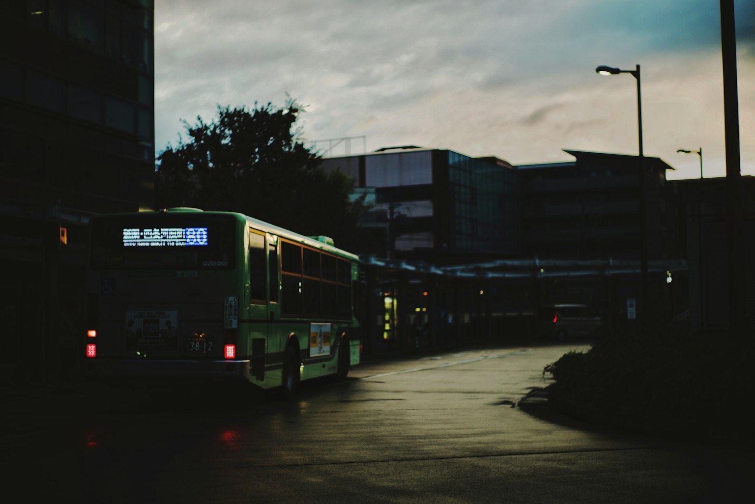 Autobus che attraversa una strada urbana poco illuminata al crepuscolo