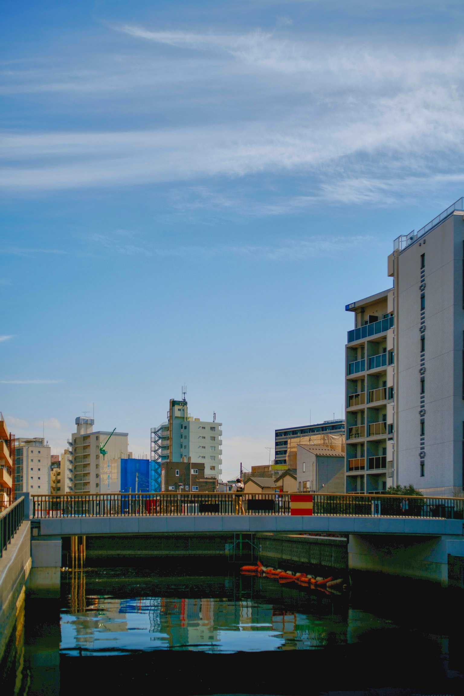 Acque tranquille che riflettono un cielo sereno e edifici moderni
