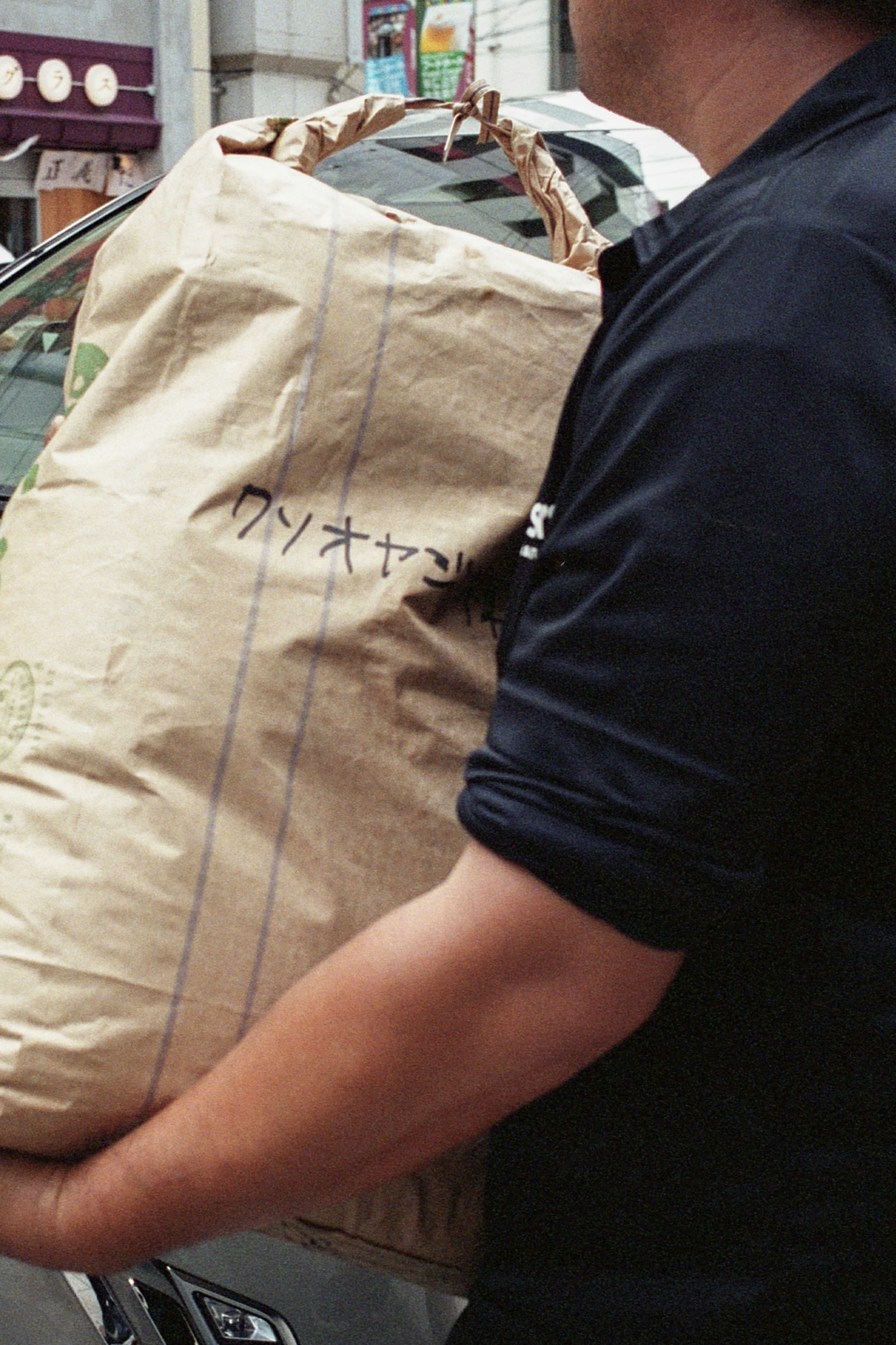 A man carrying a large package wrapped in brown paper