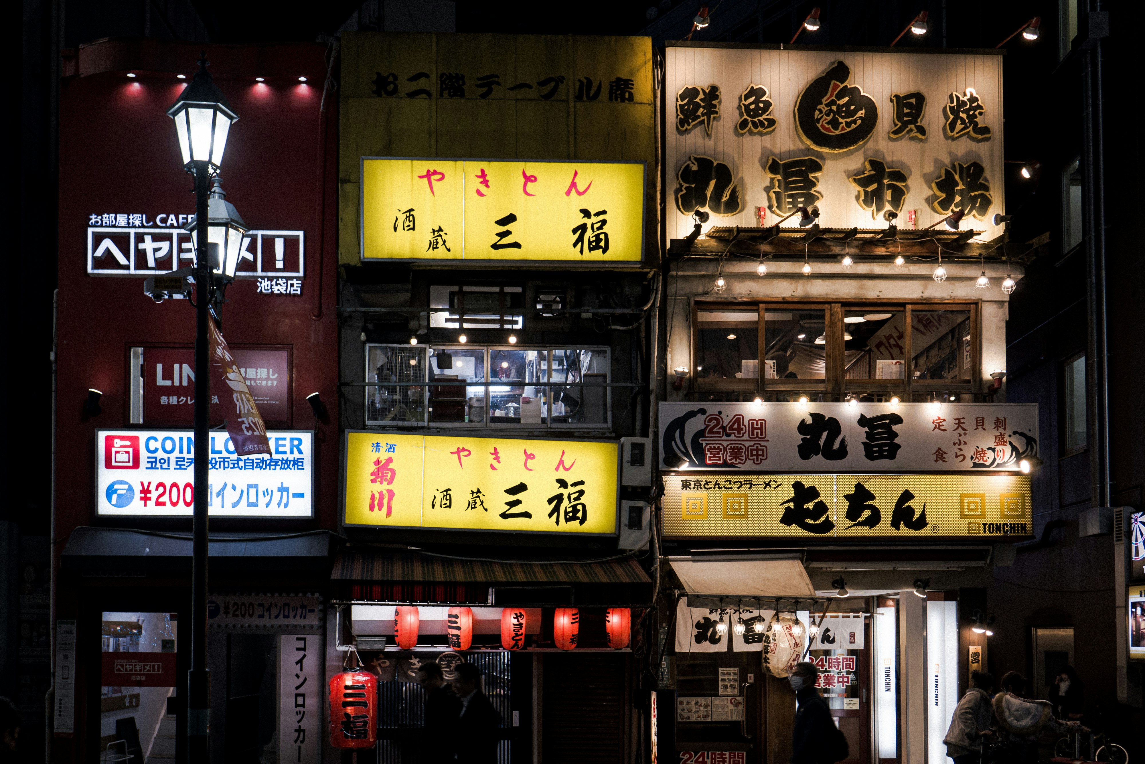 callejón nocturno en Tokio con letreros de restaurantes y faroles