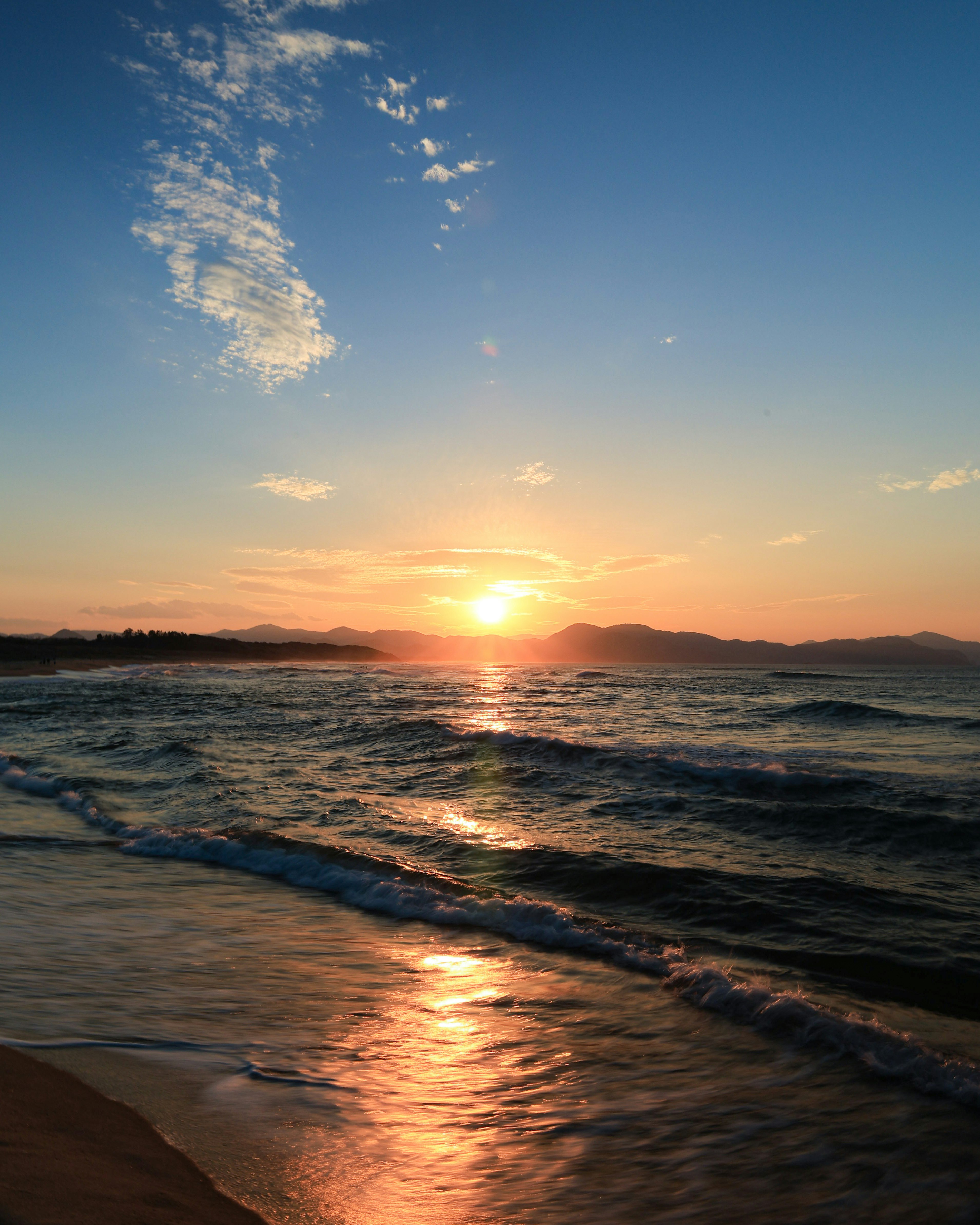美麗的海上日落波浪反射金色光芒