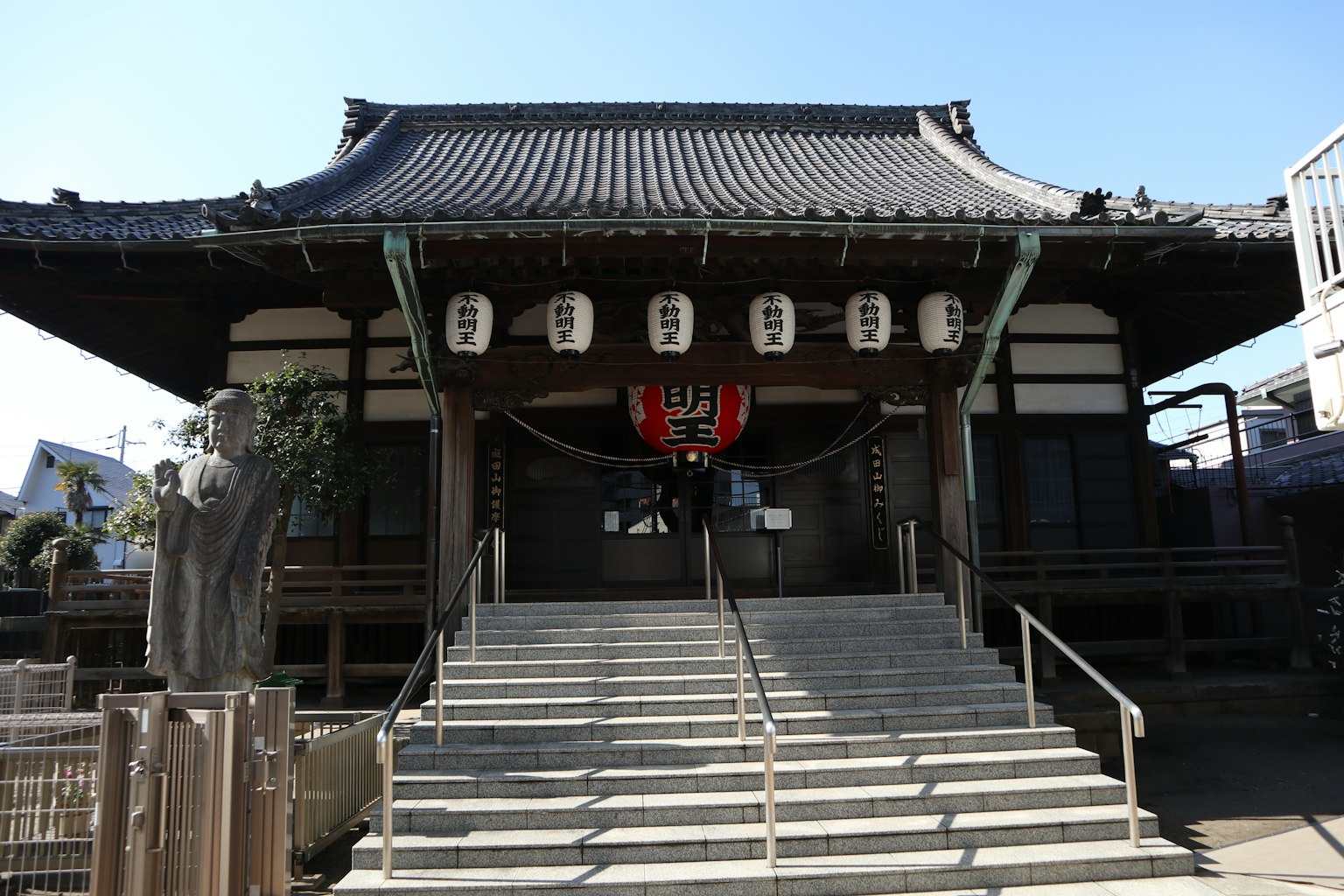 Exterior de un templo japonés tradicional grandes escalones y edificio con techo faroles y decoraciones