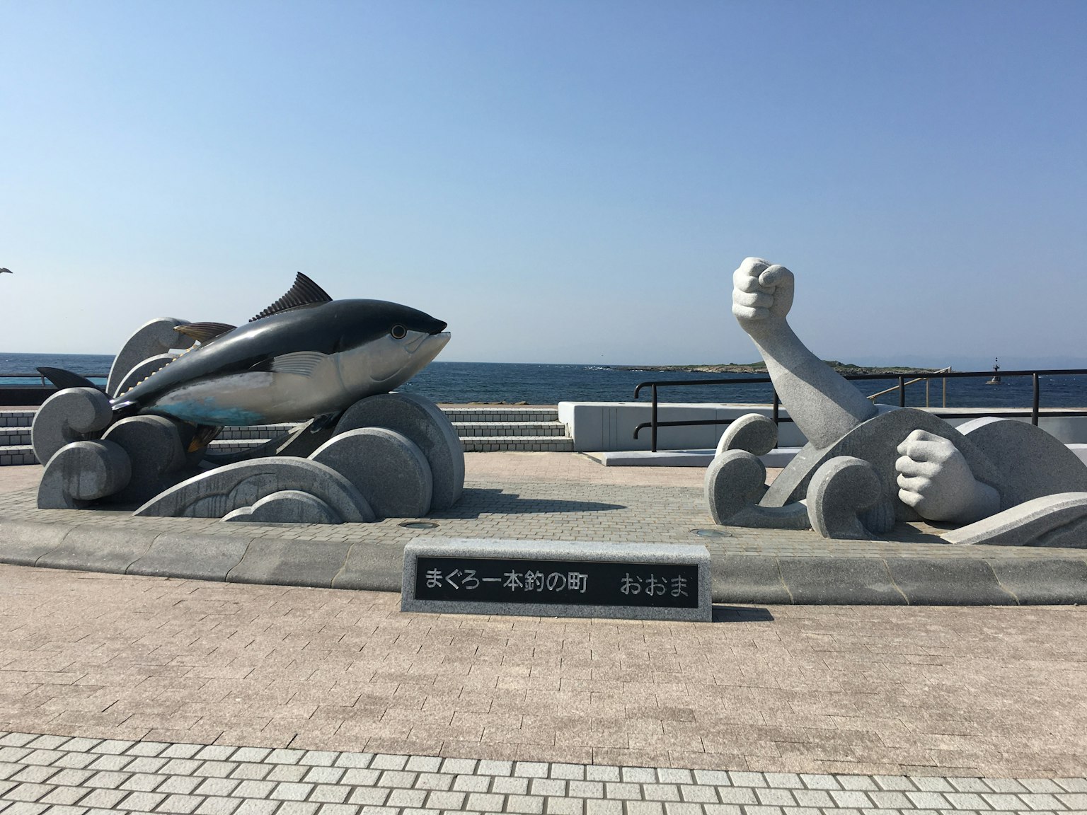 海濱步道上的海豚和人形雕塑