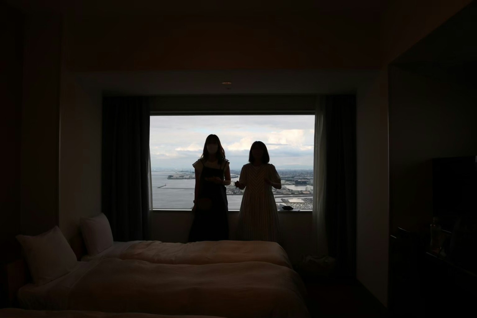 两个女人在酒店房间里看窗外