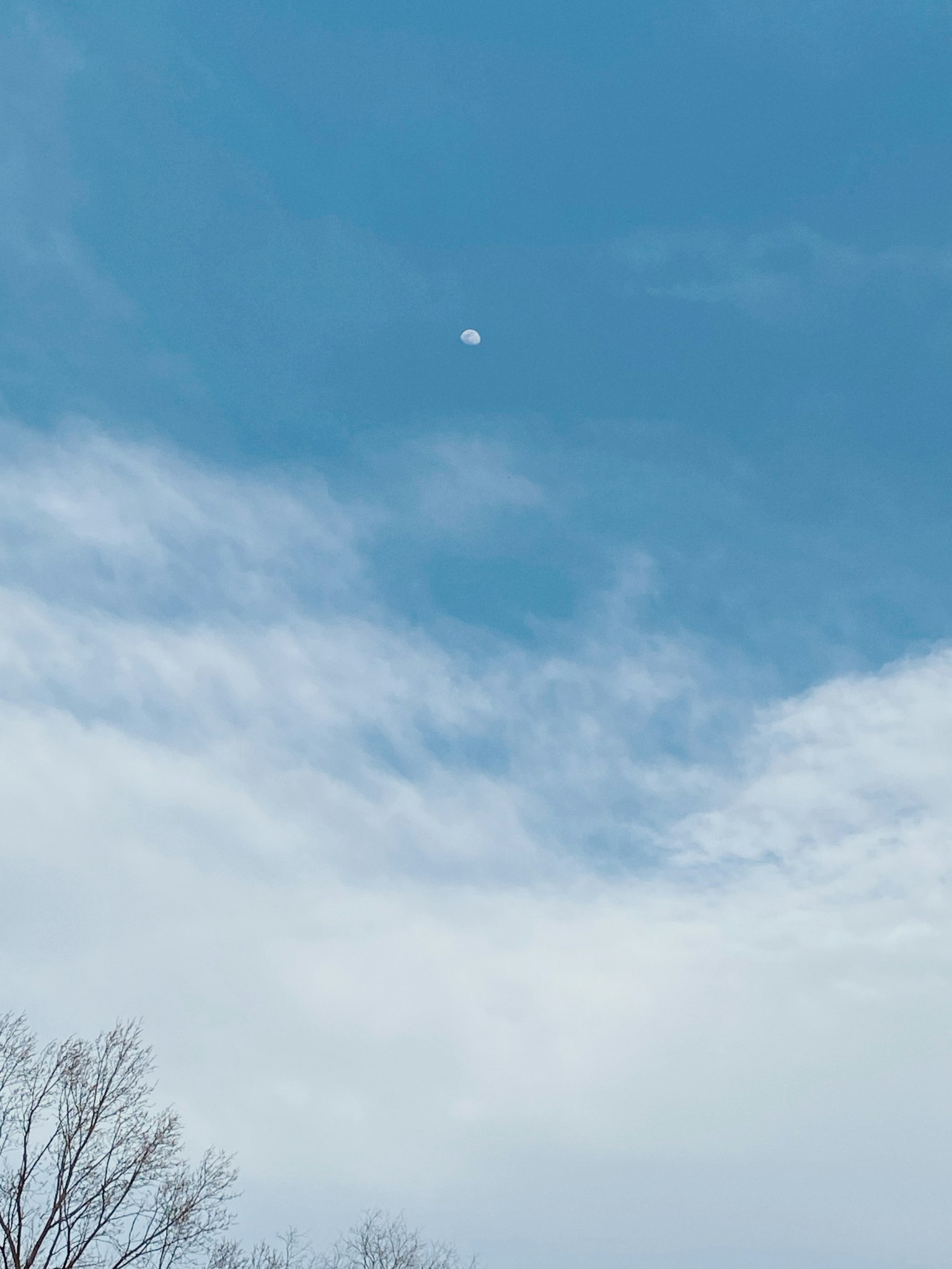 Luna bianca in un cielo blu con nuvole