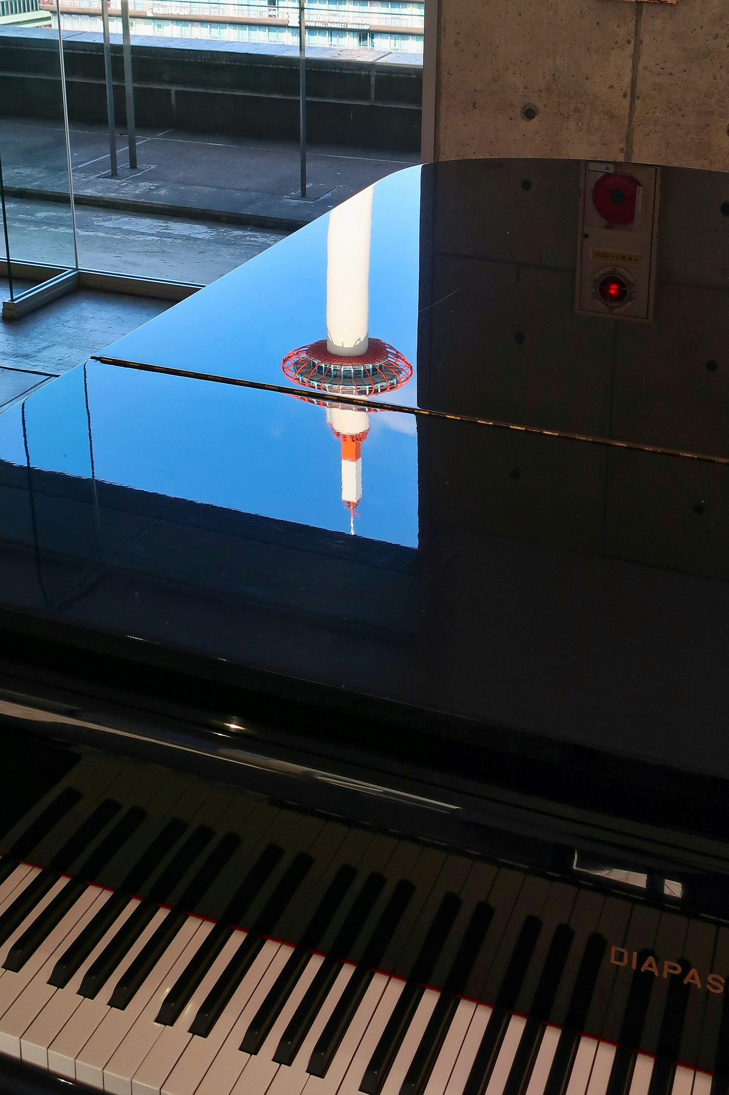 京都駅ビルの駅ピアノで演奏されるピアノの鍵盤と照明