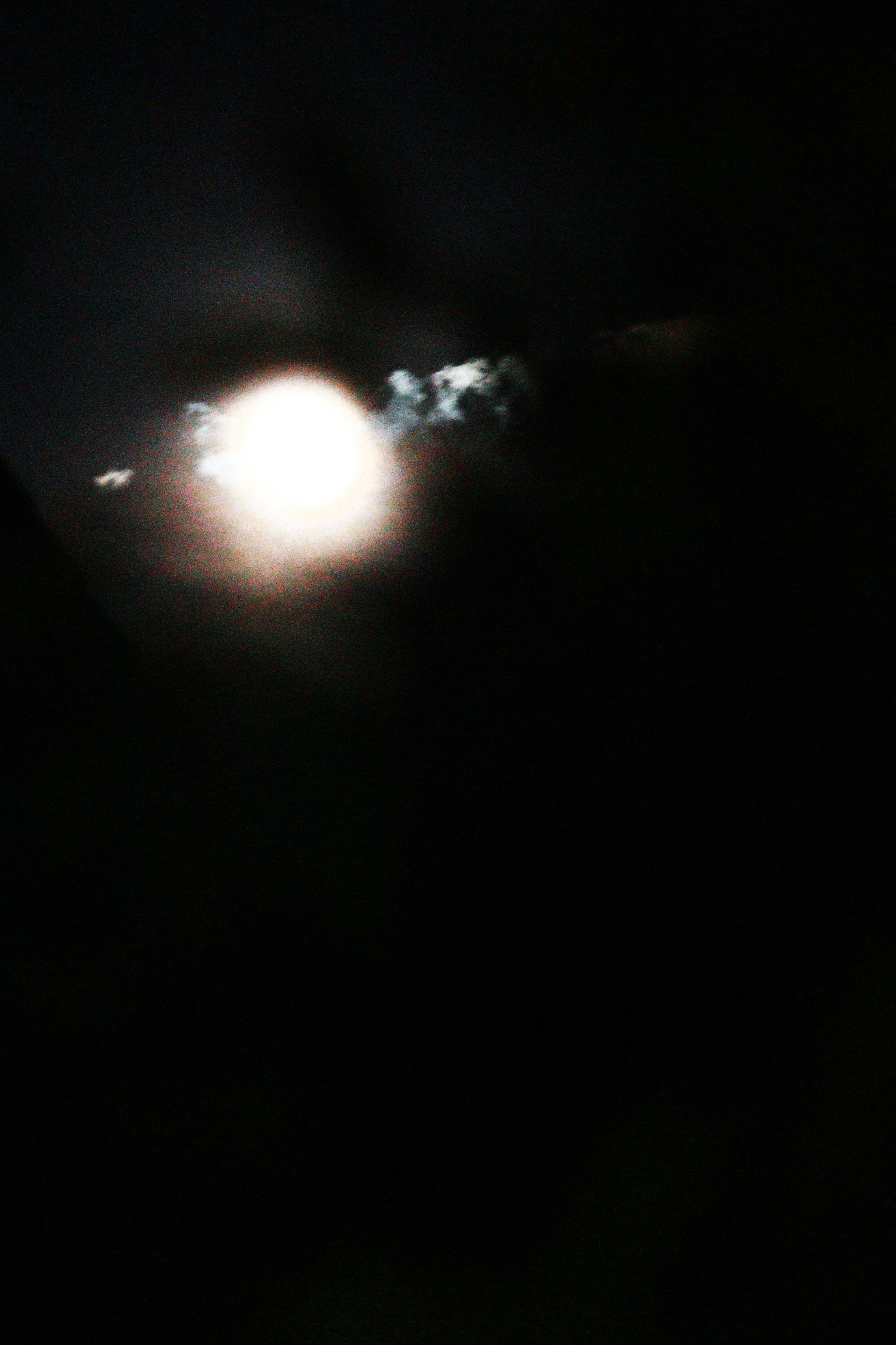 leuchtende Lichtquelle mit weichem Halo vor dunklem Hintergrund