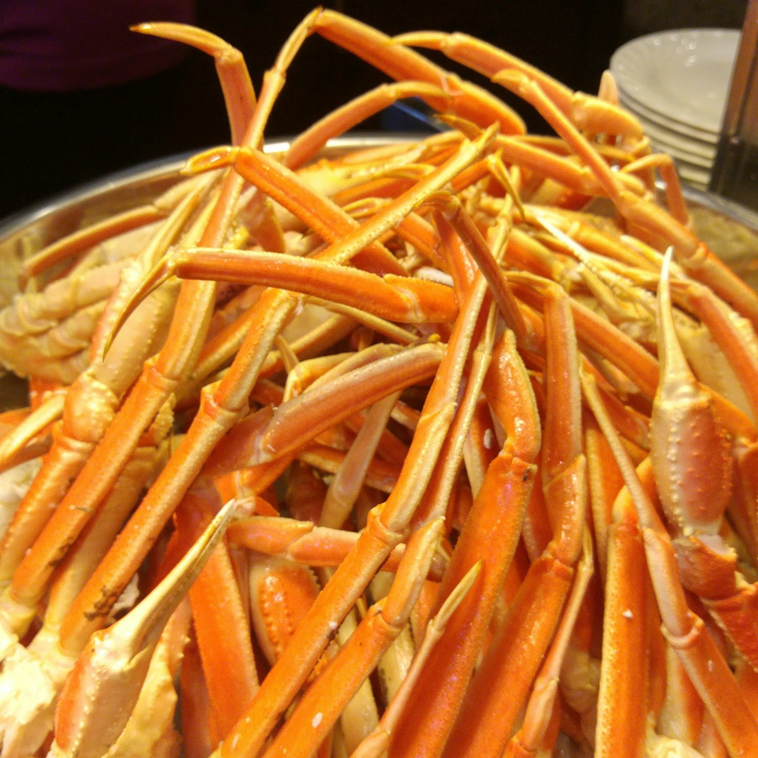 Un grand plateau rempli de pattes de crabes orange