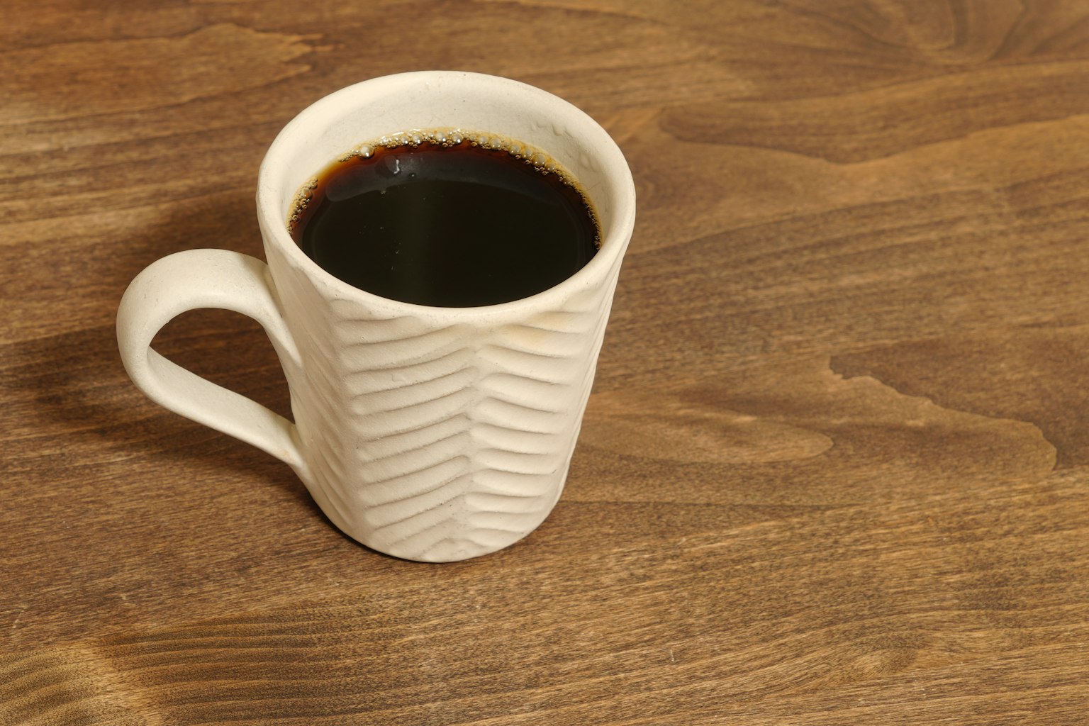 Cangkir kopi putih dengan pola diisi kopi hitam