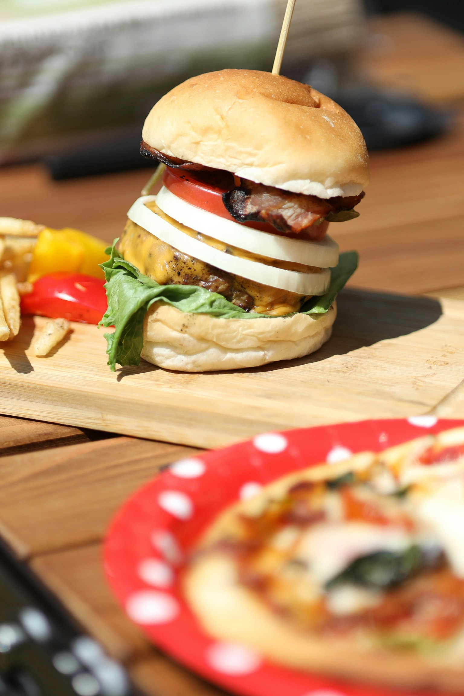 木のまな板にのったハンバーガーとキャンプ飯の料理