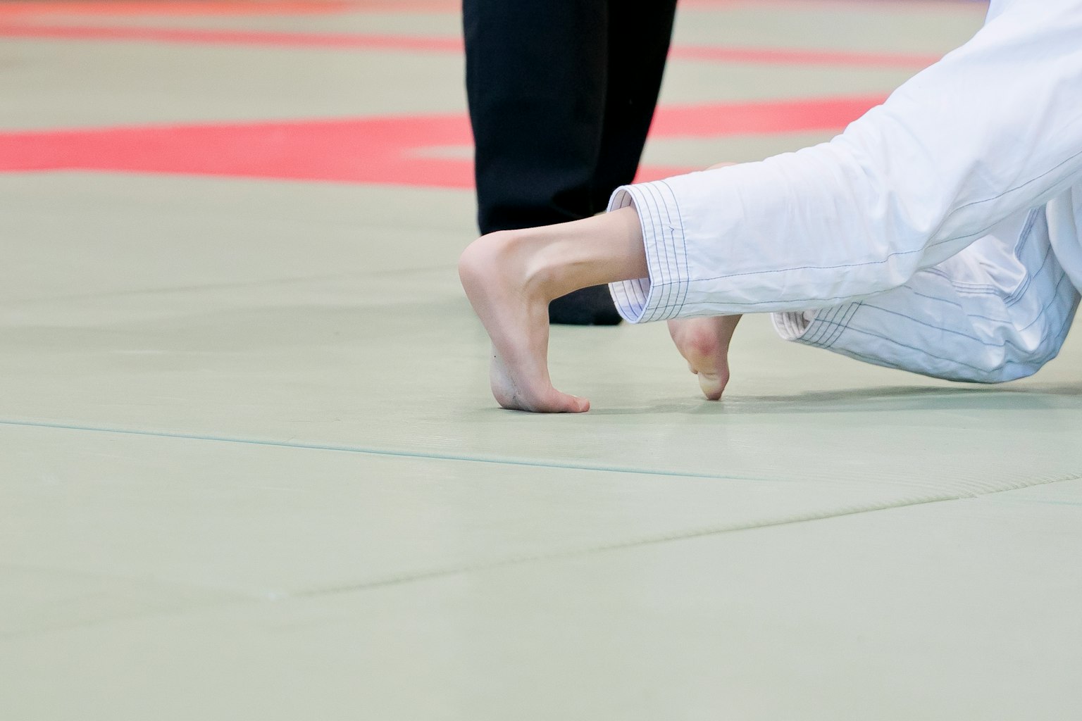 Primo piano dei piedi di un judoka durante un incontro di judo