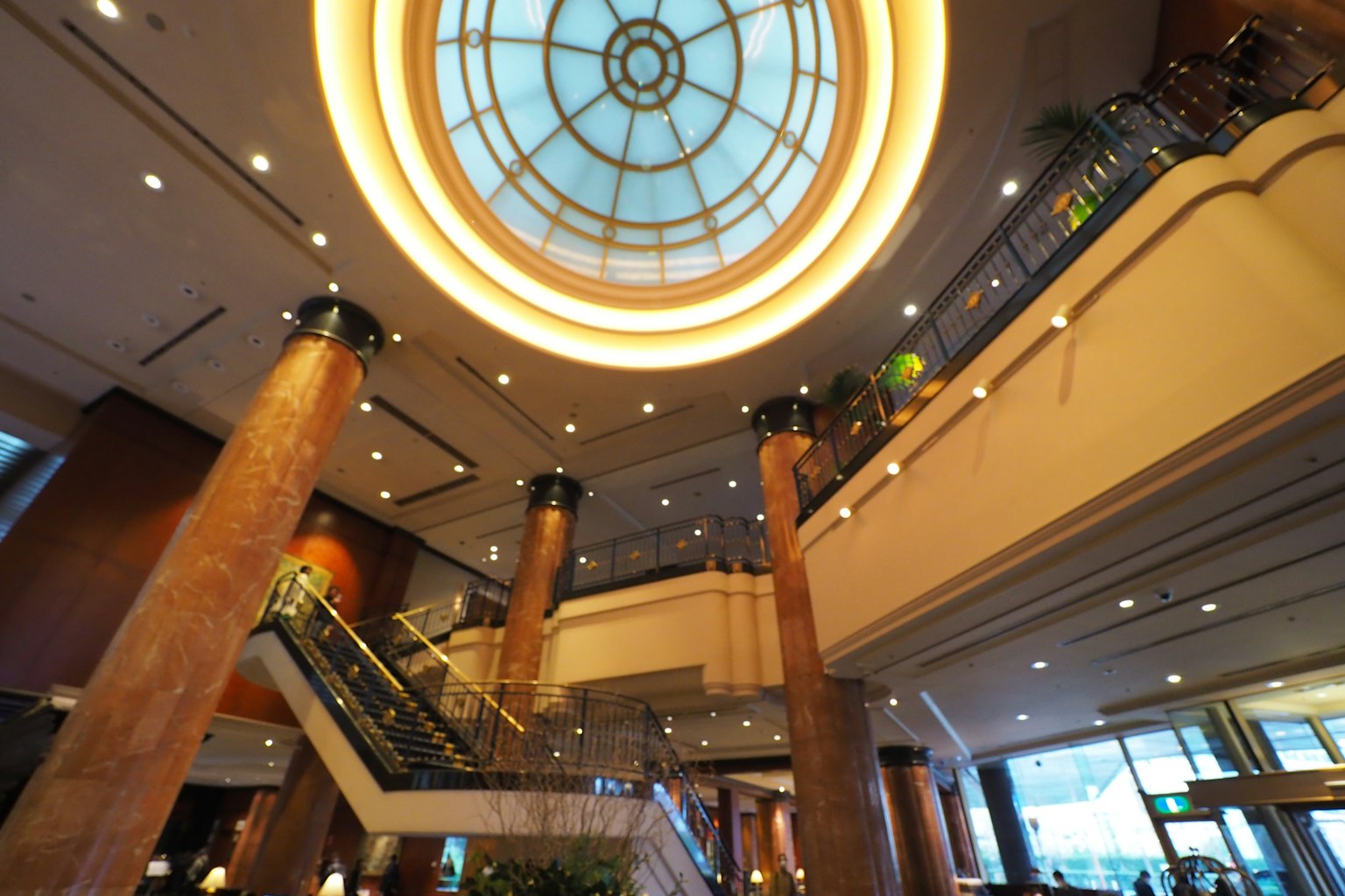 View of a luxurious lobby with a ceiling and staircase featuring unique lighting and decor