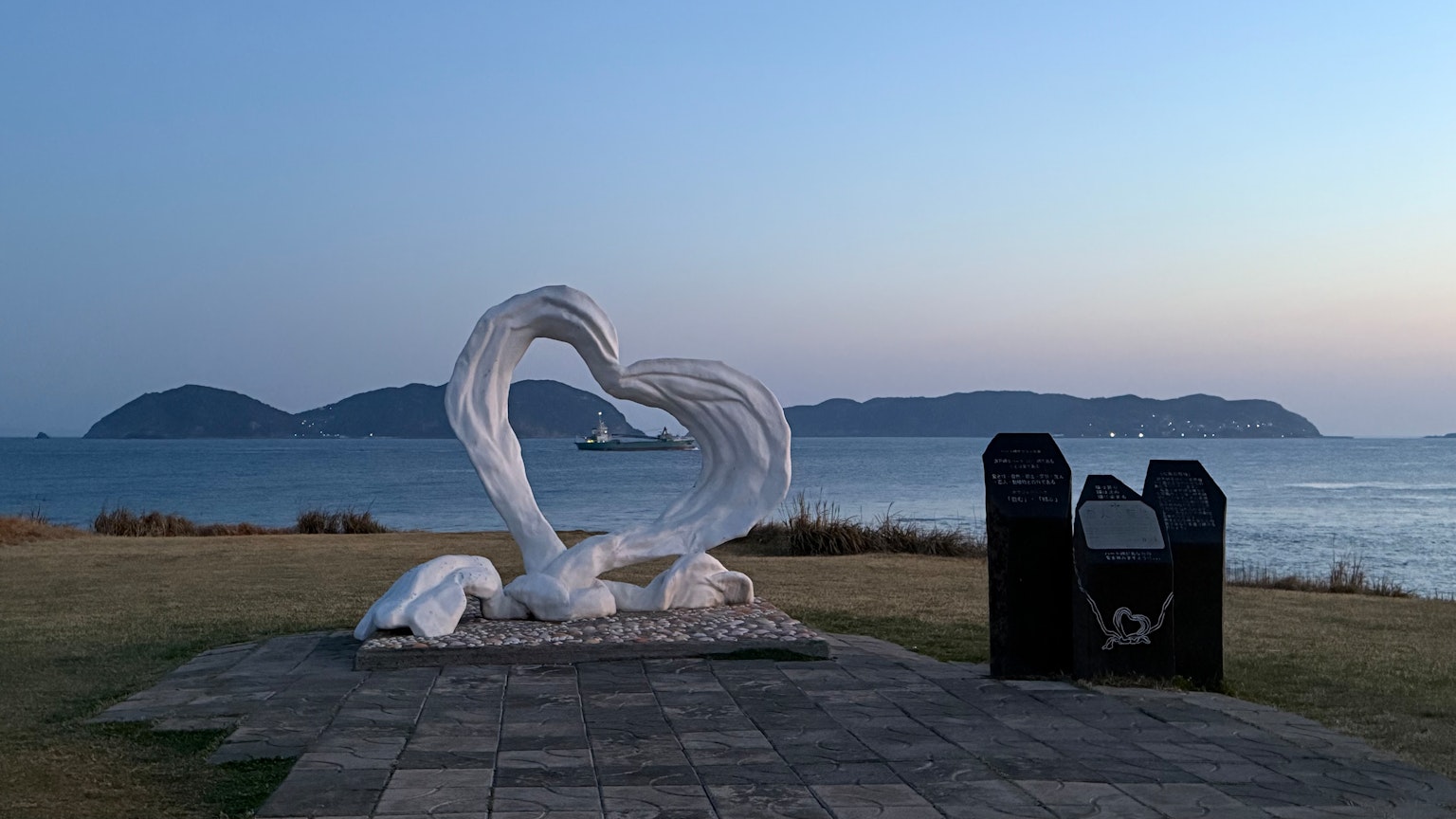 Una scultura bianca impressionante che ricorda onde con uno sfondo oceanico sereno