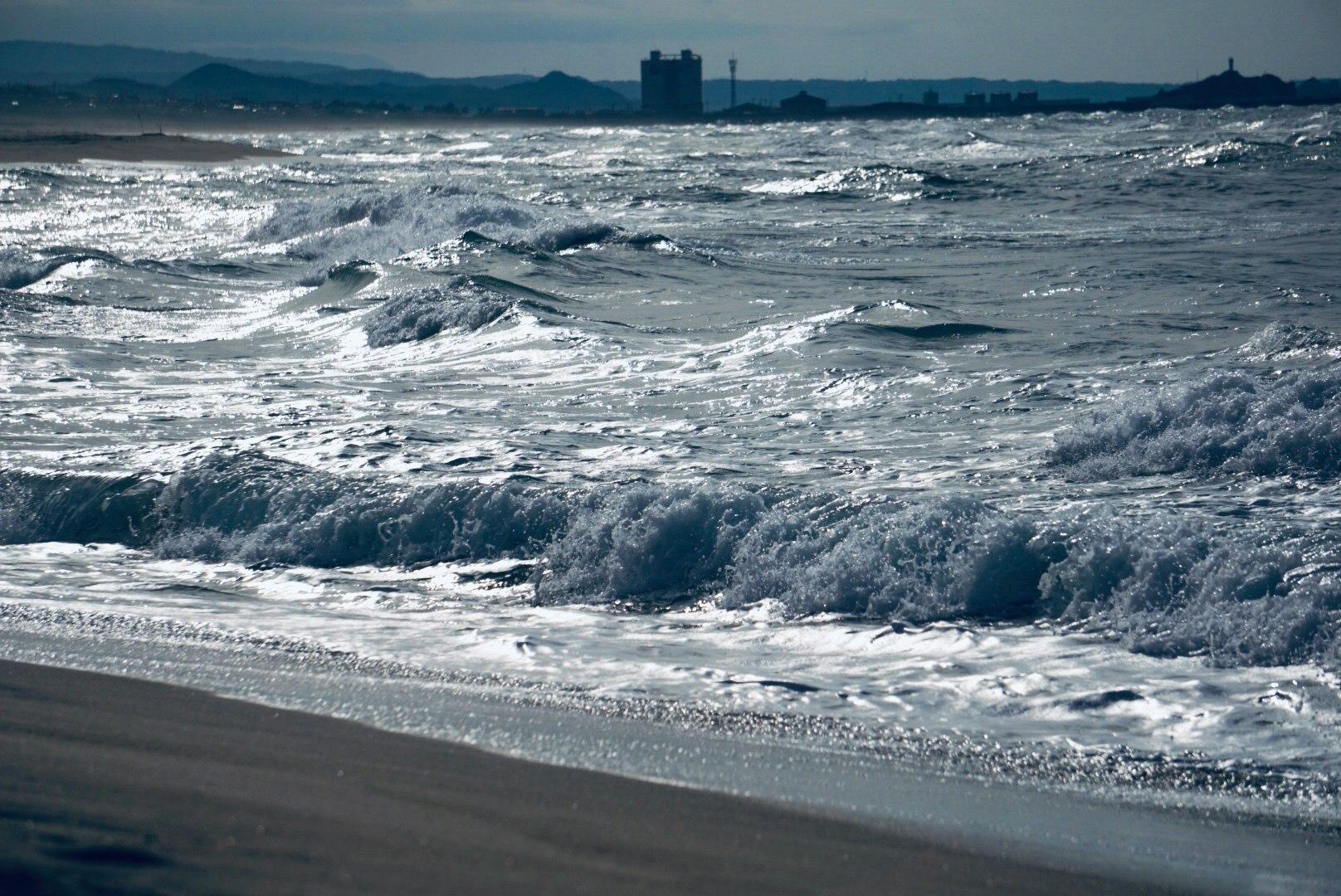 浜辺の波しぶきと海面の光