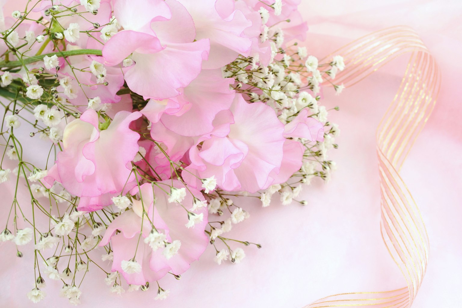 Arreglo de flores rosa claro y aliento de bebé con una cinta