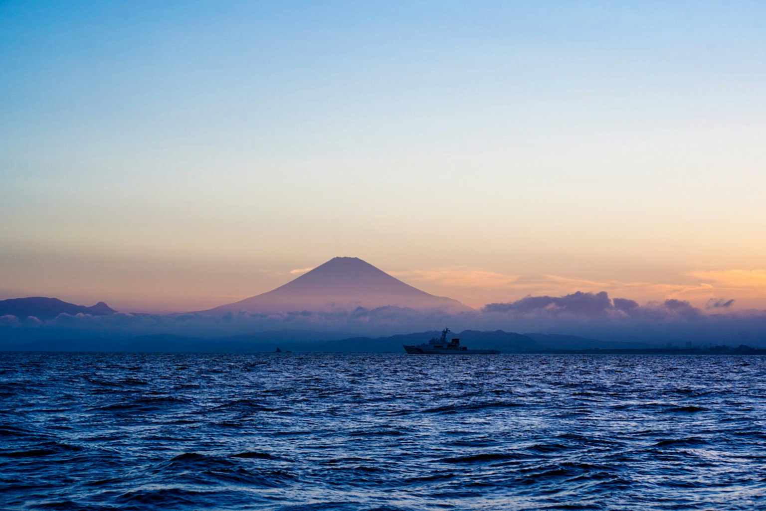 Siluet Gunung Fuji di atas laut saat matahari terbenam