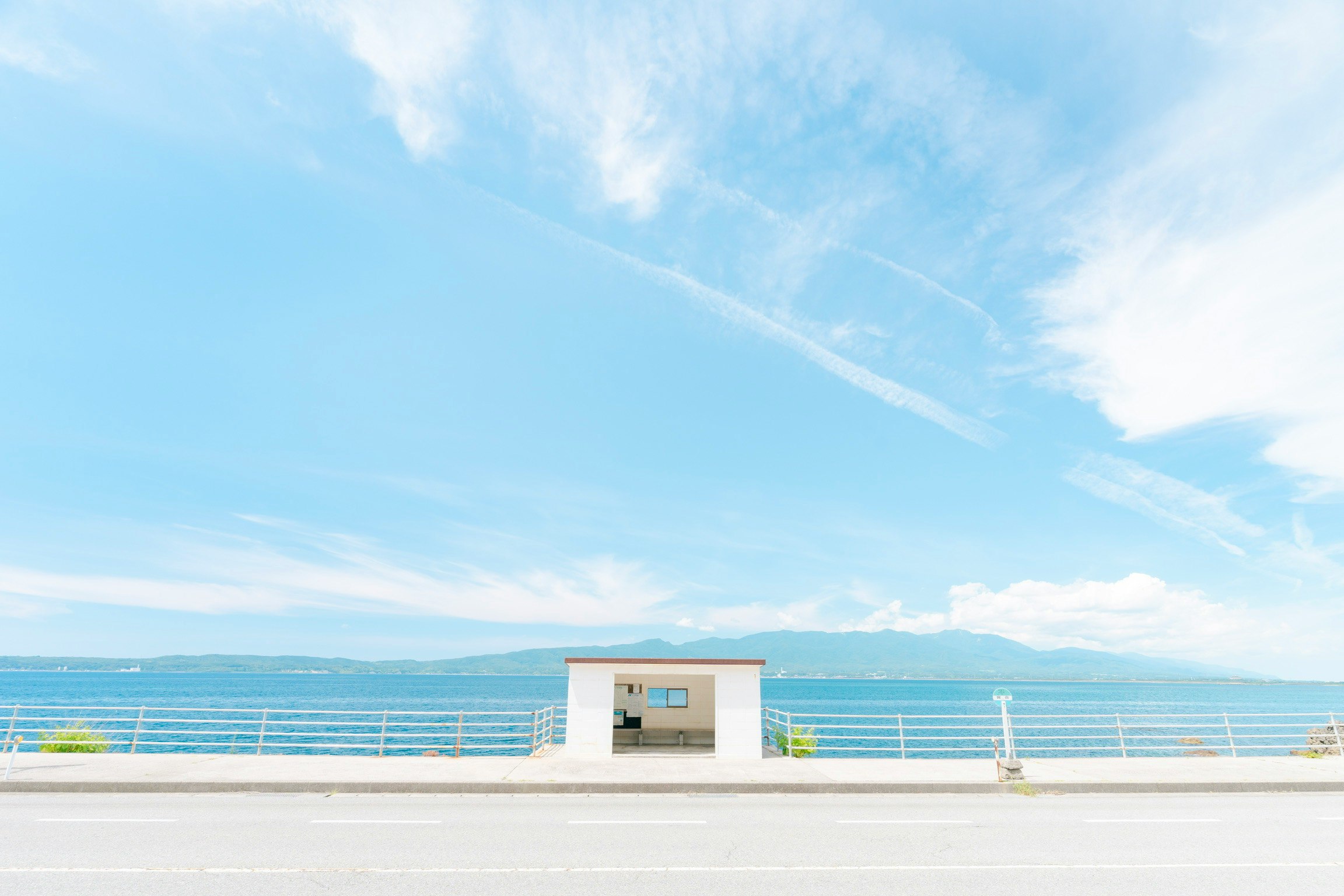 jetée blanche et petit bâtiment au bord de la mer sous un ciel bleu