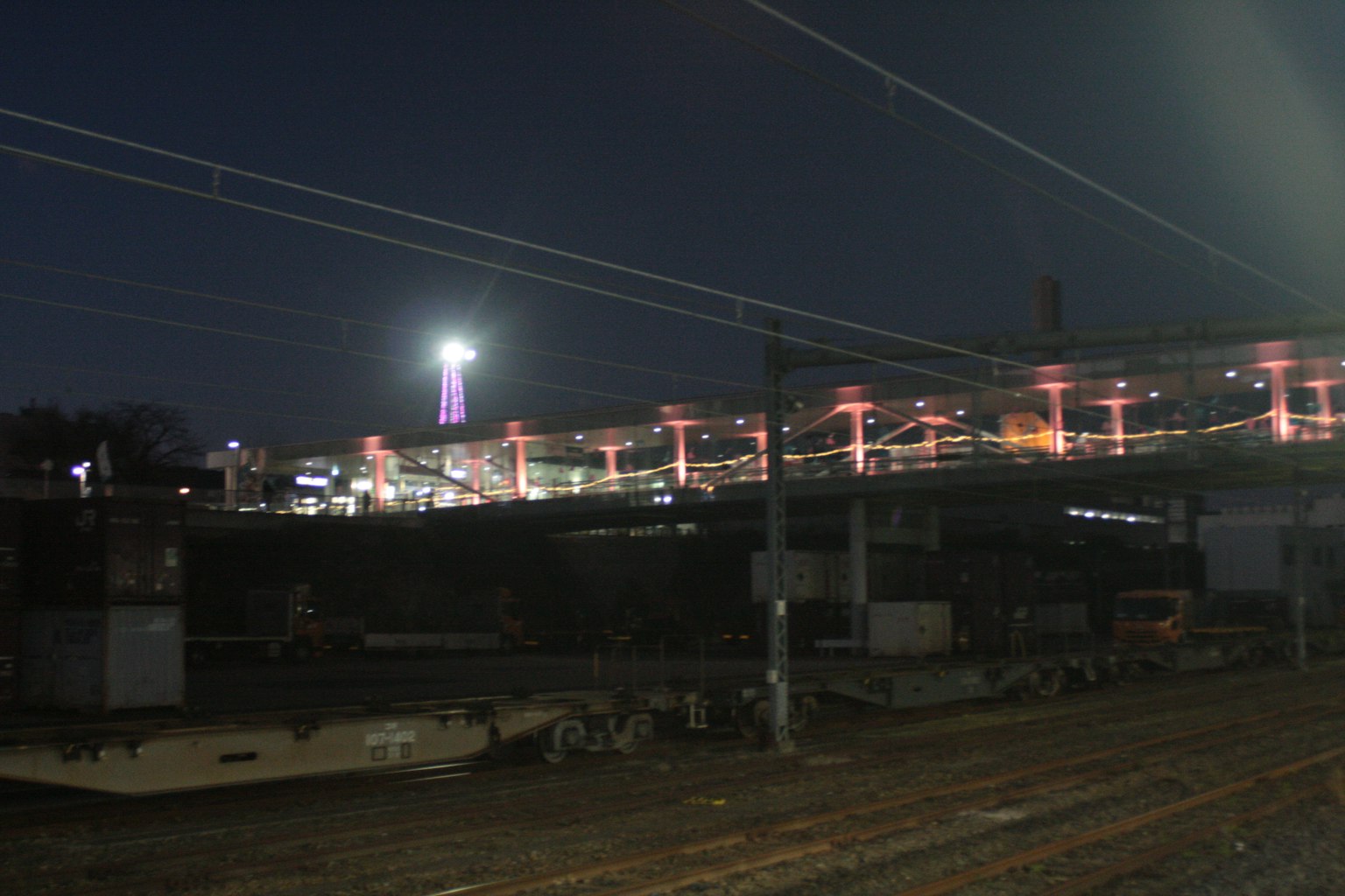ทิวทัศน์ตอนกลางคืนของสะพานรถไฟพร้อมแสงสว่างรอบๆ