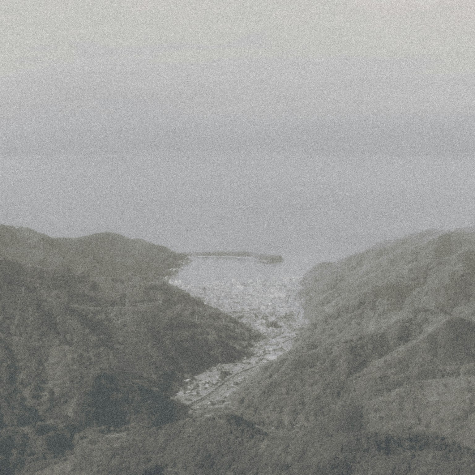 Vista della costa nebbiosa con montagne sullo sfondo