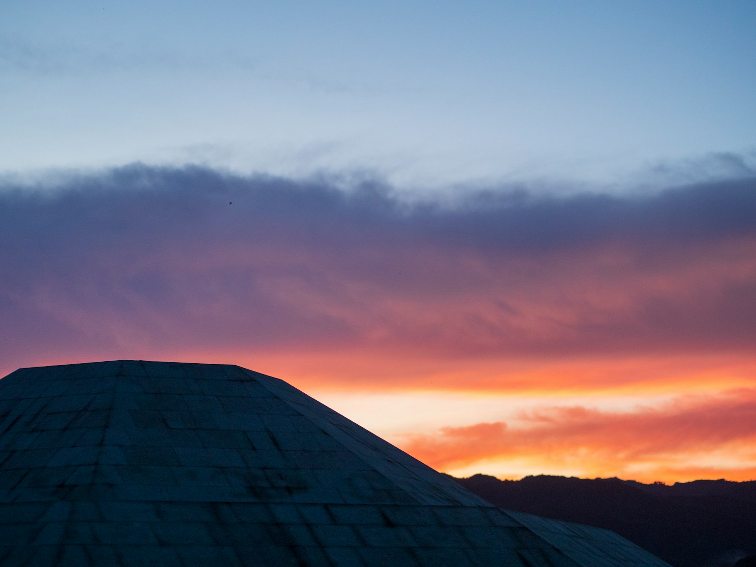 Silhouette of a mountain against a sunset sky