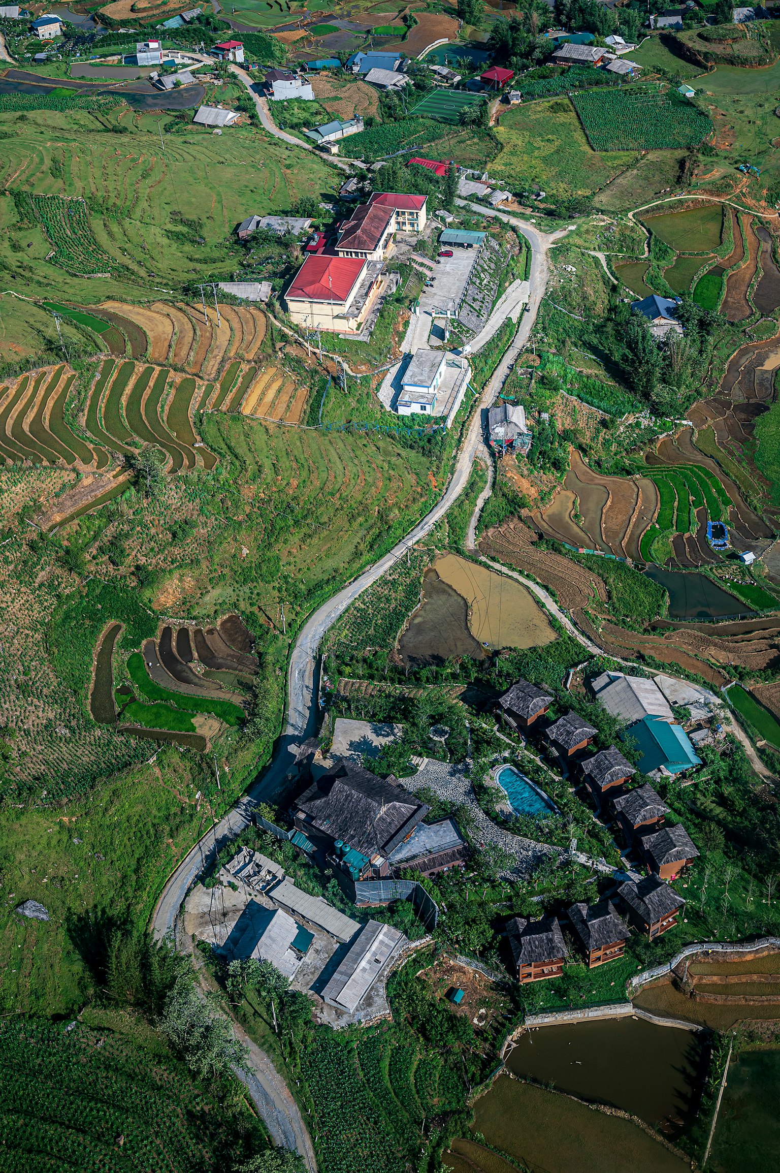 Vista aerea di un villaggio circondato da una bella campagna con risaie verdi e case