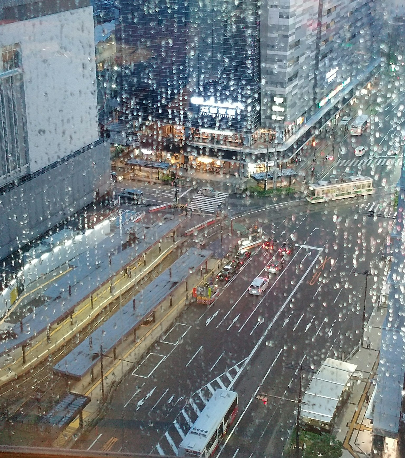Cityscape view through a rainy window showcasing streets and buildings