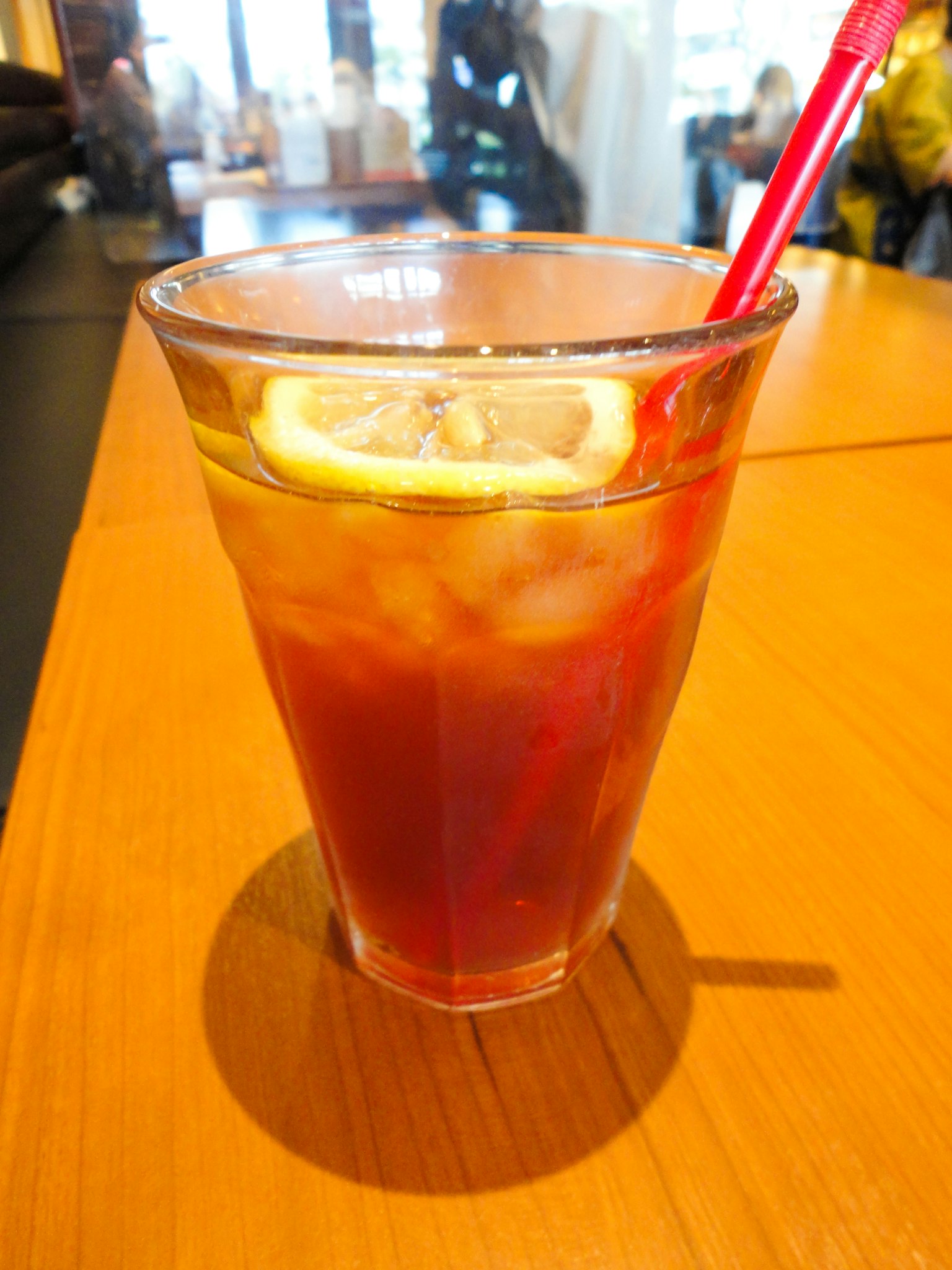 Un bicchiere di tè freddo con cubetti di ghiaccio e fette di limone