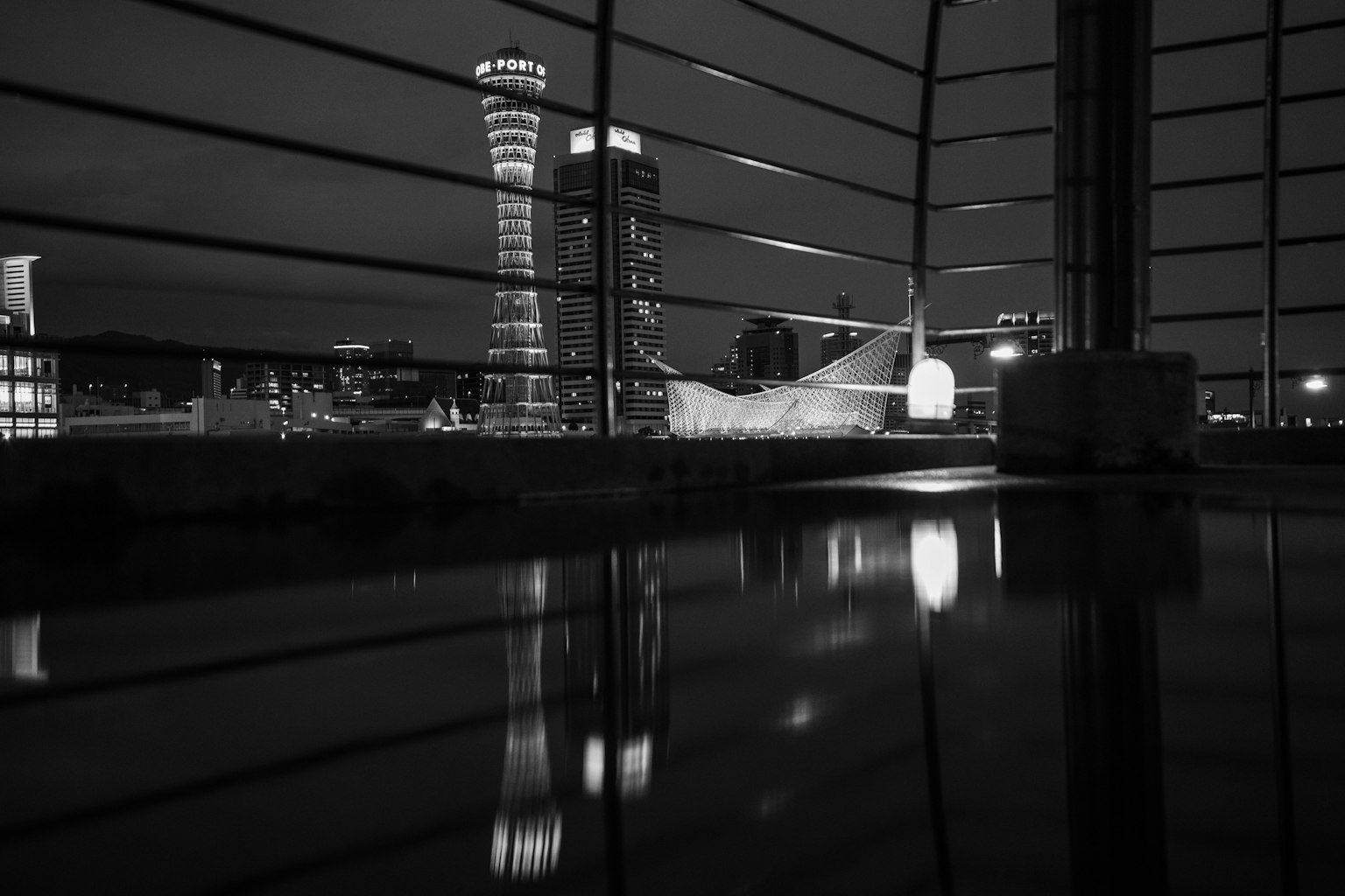 Pemandangan kota malam hitam putih dengan gedung pencakar langit dan refleksi