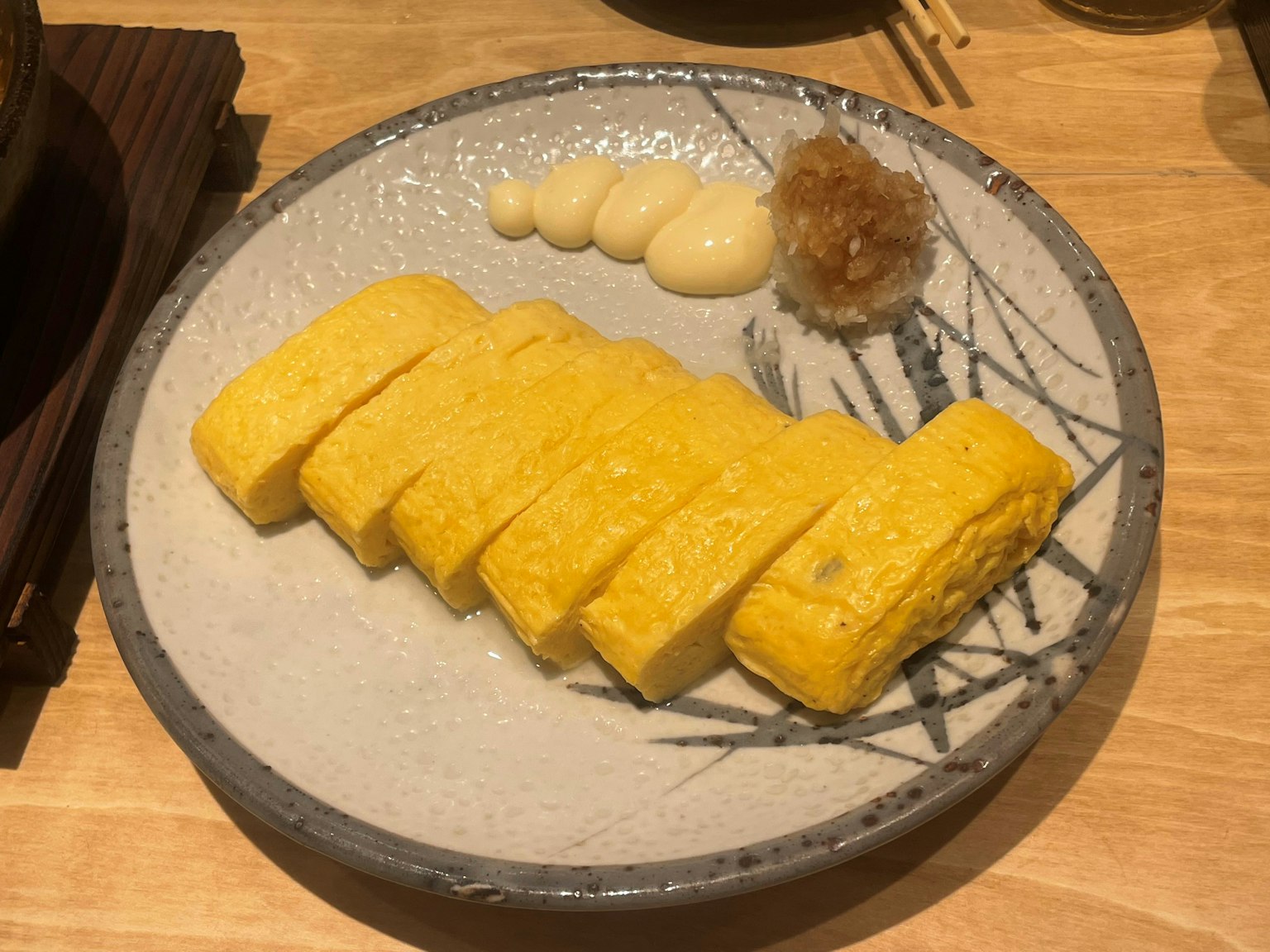 Beautifully presented tamagoyaki with accompanying sauces