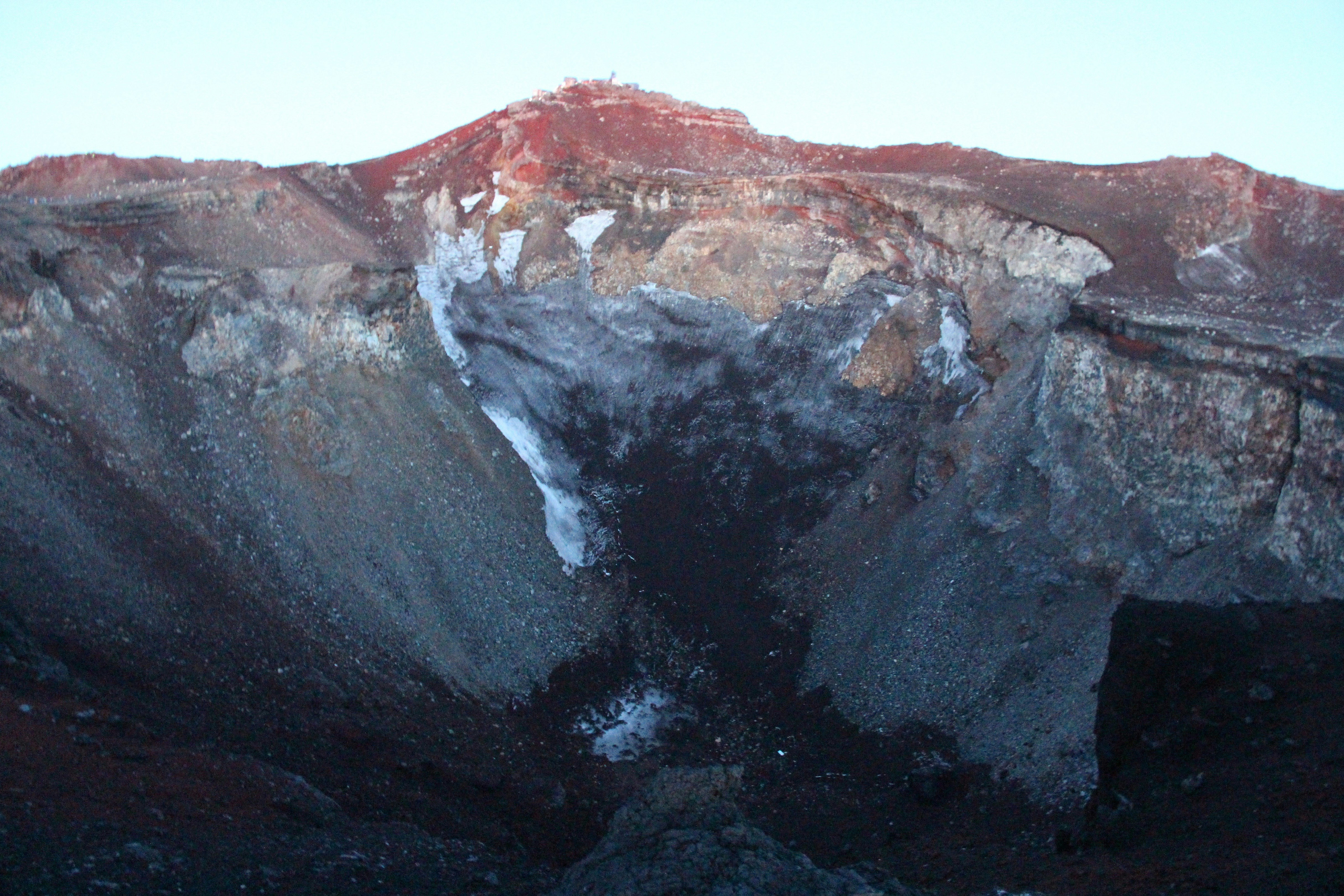 噴火口から噴煙が立ちのぼる火山の頂上の景色