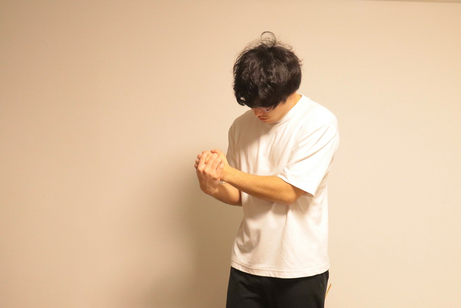 穿白色T恤的男人雙手合十站立