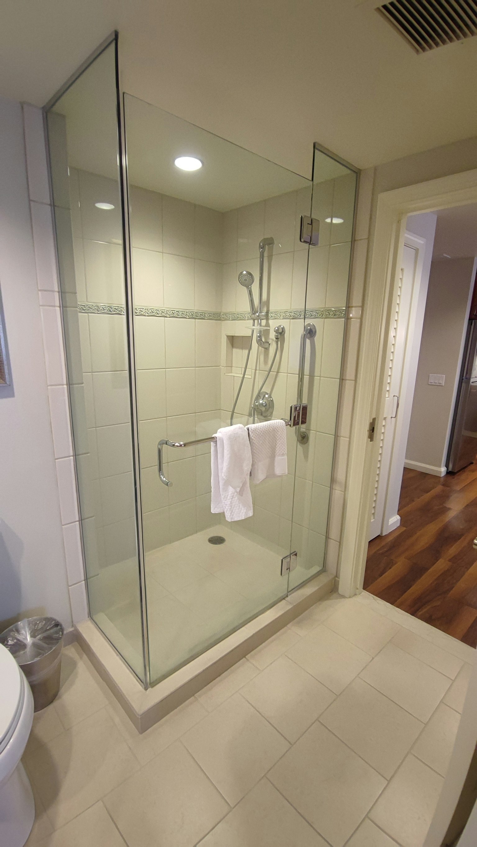 Bagno moderno con cabina doccia in vetro e asciugamano bianco