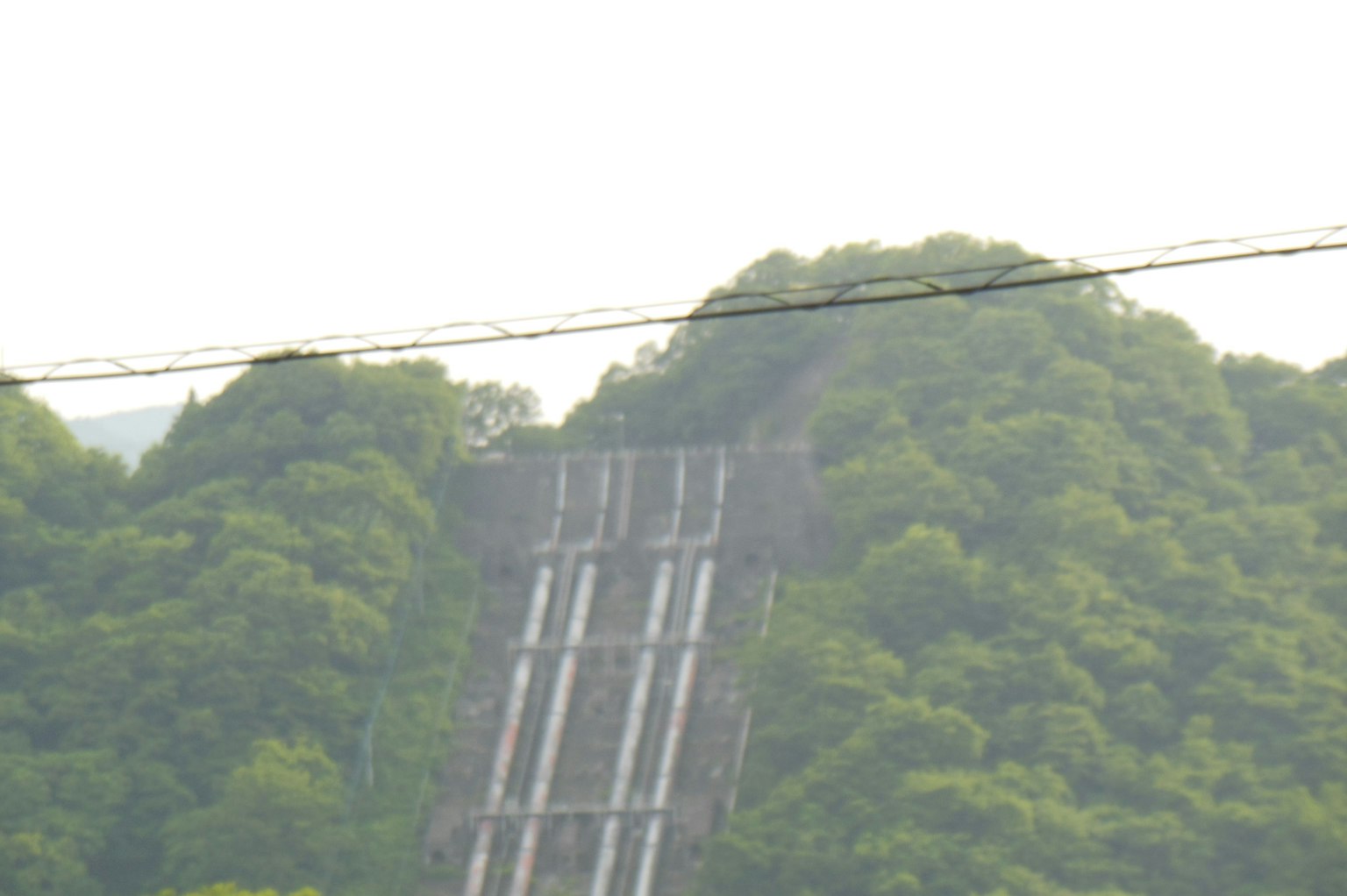 Grande structure de barrage sur une colline recouverte de verdure